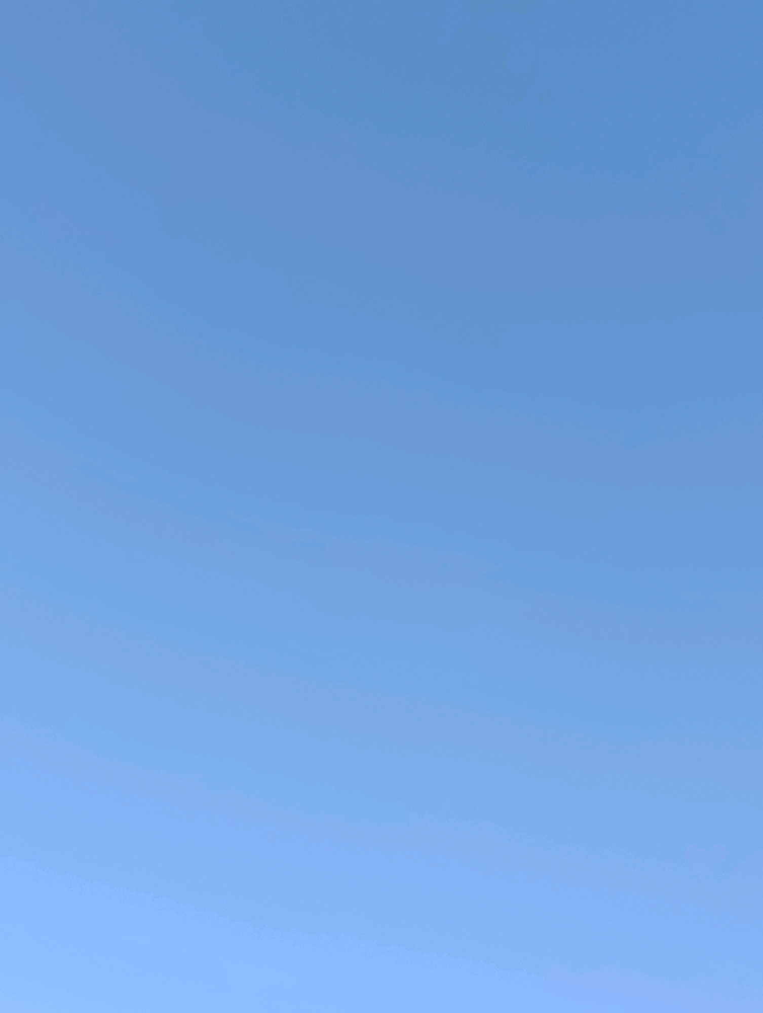 The image displays a vast expanse of clear blue sky. There are no discernible subjects, objects, actions, or interactions visible. The environment is a cloudless sky, with a subtle gradient of lighter blue towards the bottom of the frame. There is no indication of Cherkasy, Ukraine, or any other specific location within the image.