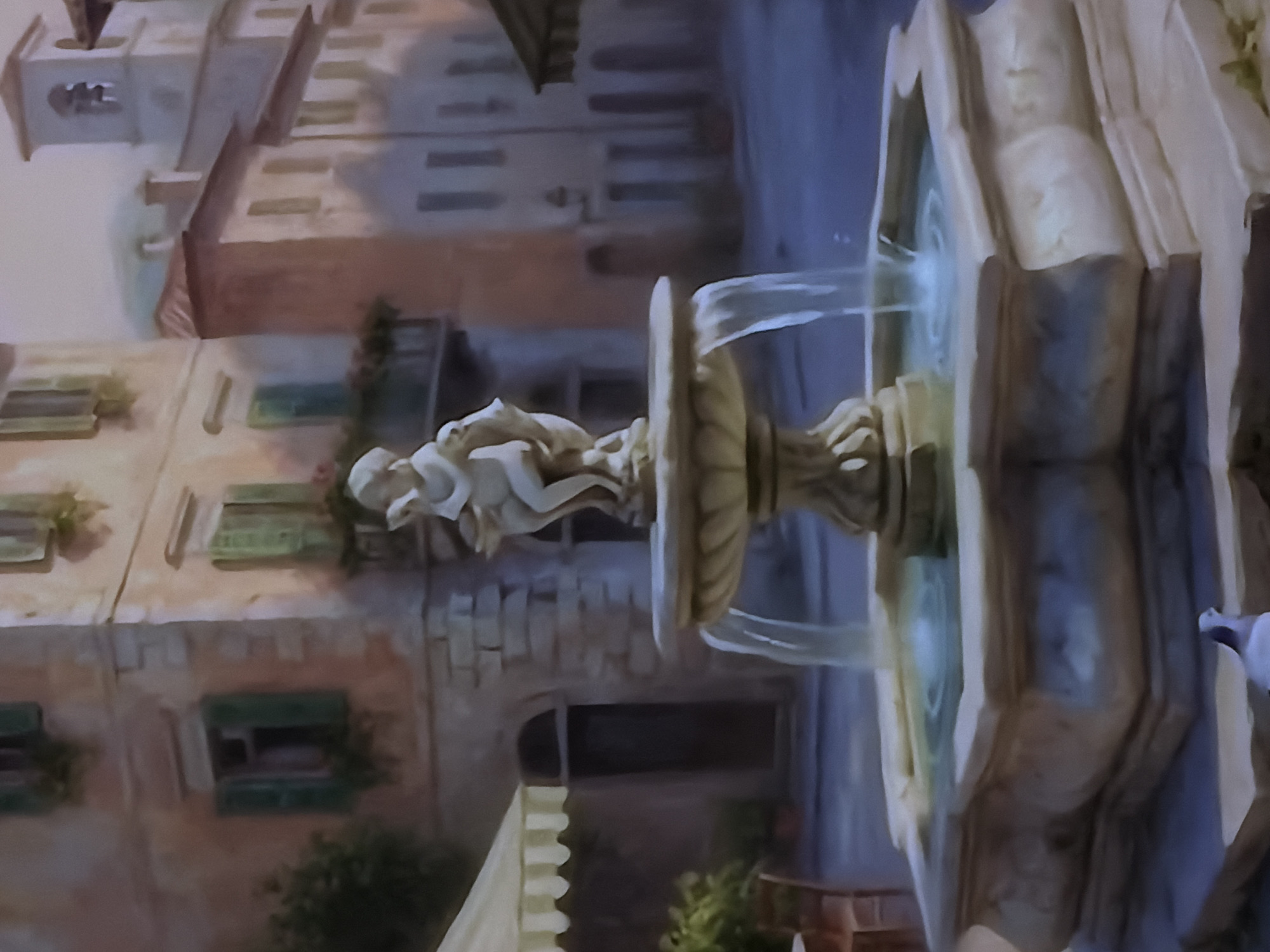 This image captures a painting or mural depicting a tranquil European town square scene, likely set in Sofiivska Borshchahivka, Ukraine, as a decorative feature. The central subject is a multi-tiered stone fountain, from which water cascades into lower basins. A light-colored statue, appearing to be a cherub or child-like figure, stands atop the fountain's highest tier.
In the background, aged buildings with warm, earthy tones and multiple windows with green shutters line the square, creating an impression of an old-world village or city street. Some windows have small plants or flower boxes. The architectural style suggests a Mediterranean or Italian influence. Green foliage and small bushes are visible at the base of some buildings, adding to the picturesque setting.
The lighting is soft and diffused, indicating a calm time of day, possibly daylight or late afternoon, contributing to a serene atmosphere. There is no visible text or explicit activity beyond the flowing water from the fountain. The overall impression is one of peaceful charm, evoking the ambiance of a historic European locale.