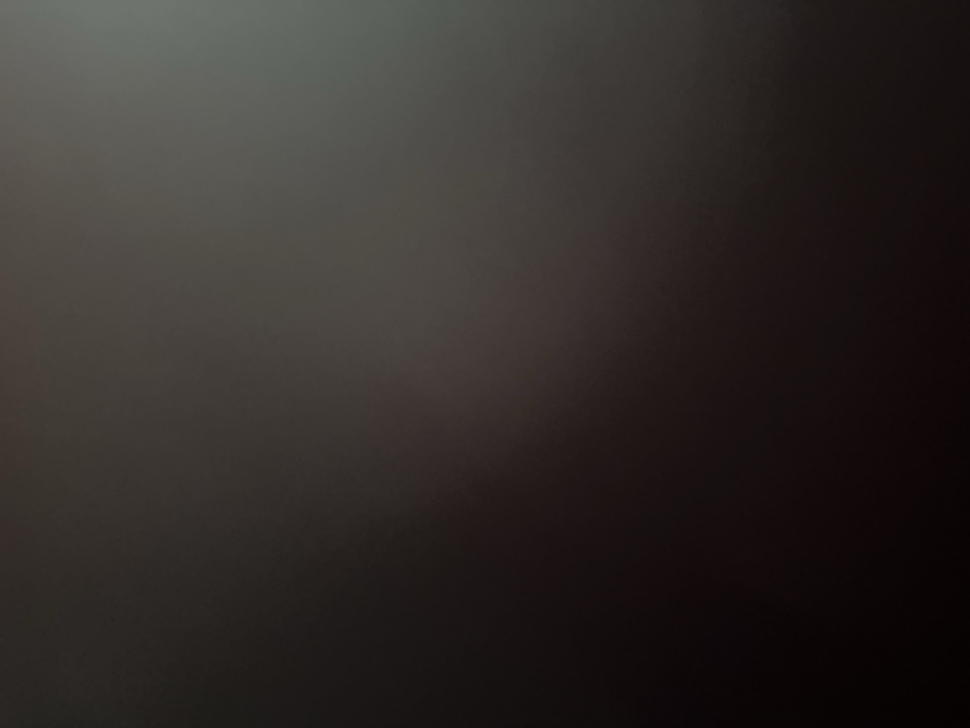 This is a poorly lit, out-of-focus image with a gradient of dark grey to lighter grey, possibly indicating a wall or a surface under low light conditions. There are no discernible people, subjects, objects, actions, interactions, or environmental features visible in the image. The location in Zvezdara Urban Municipality, Serbia, cannot be determined from the visual information provided.