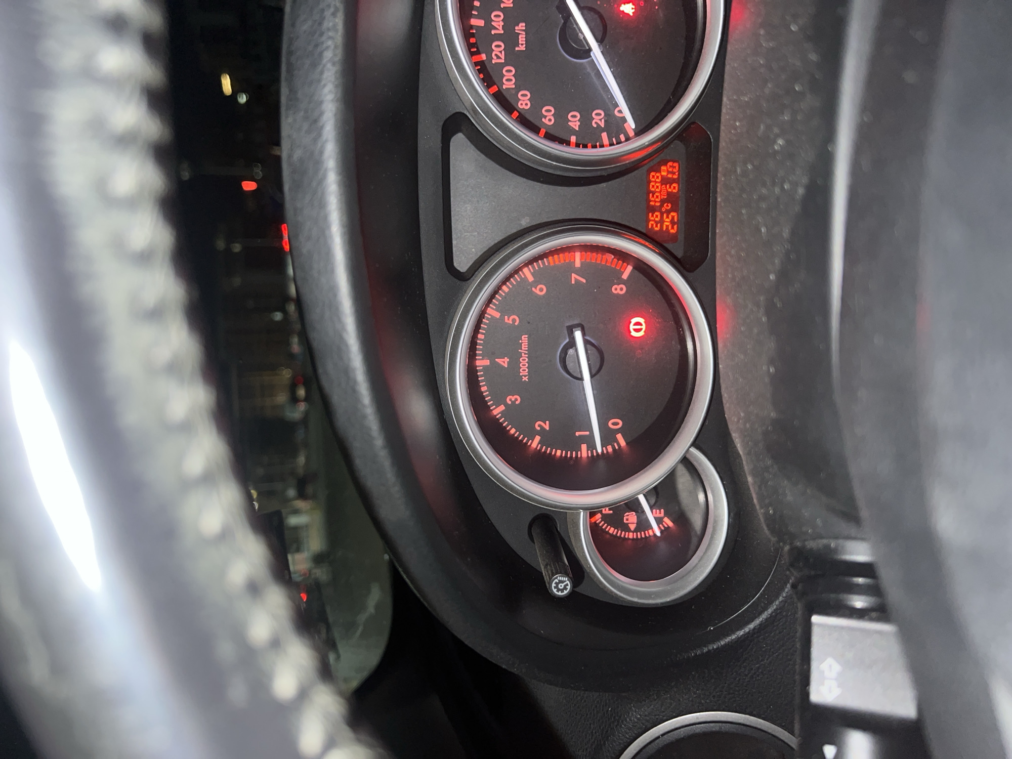 The image shows the dashboard of a vehicle. The odometer reads 261688, the trip meter reads 61.0 and the car is running at about 750 RPM. The fuel gauge shows less than a quarter of a tank. The tire pressure warning light is illuminated. The speedometer reads approximately 10km/h. The location is unknown and there are no people visible in the image.