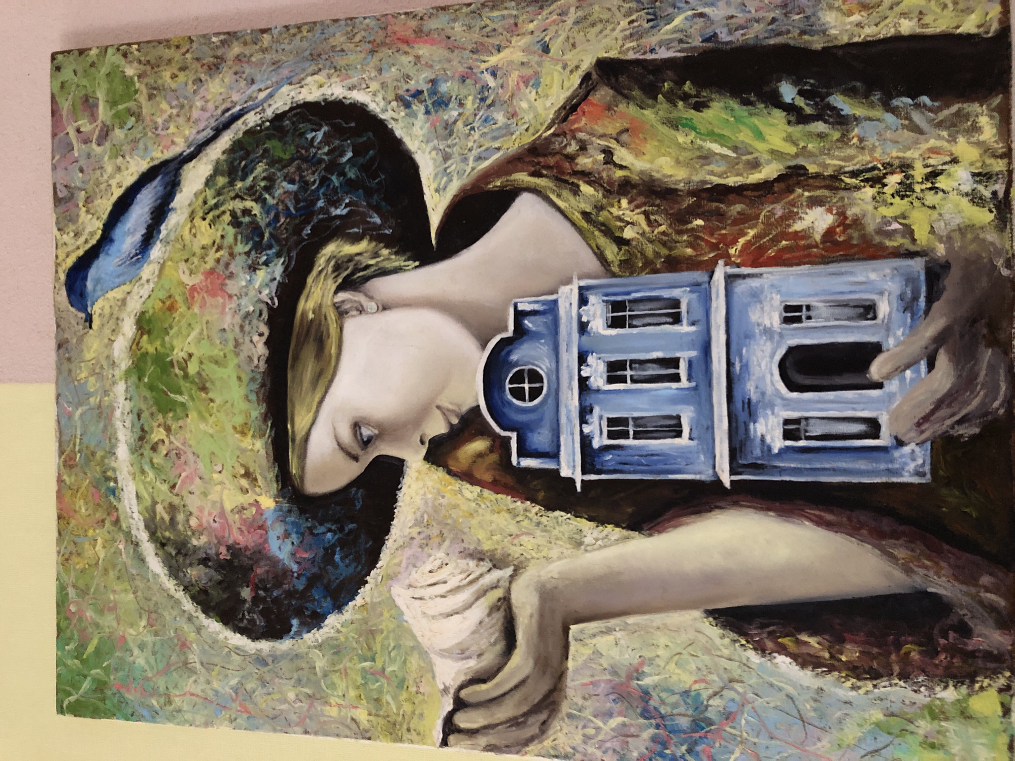 This vibrant, abstract painting, presented horizontally, depicts a woman and symbolic objects. The main subject is a woman's profile from the chest up, with her head oriented towards the left side of the frame. She has fair skin and light-colored hair, and her gaze is directed downwards, conveying a contemplative or introspective mood. She wears a large, wide-brimmed hat, predominantly dark, with a striking blue element resembling a feather or ribbon extending from it.
In her right hand, she delicately holds a miniature, stylized blue house. This two-story structure features multiple white-framed windows and a distinct circular window on one side. Her left hand cradles a large, intricately spiraled white shell, possibly a conch.
The background is highly textured and abstract, characterized by expressive, impasto brushstrokes. A rich palette of greens, yellows, blues, reds, and pinks creates a dynamic and chaotic yet harmonious setting, evoking a dreamlike or surreal atmosphere around the figure. No text is visible in the artwork.