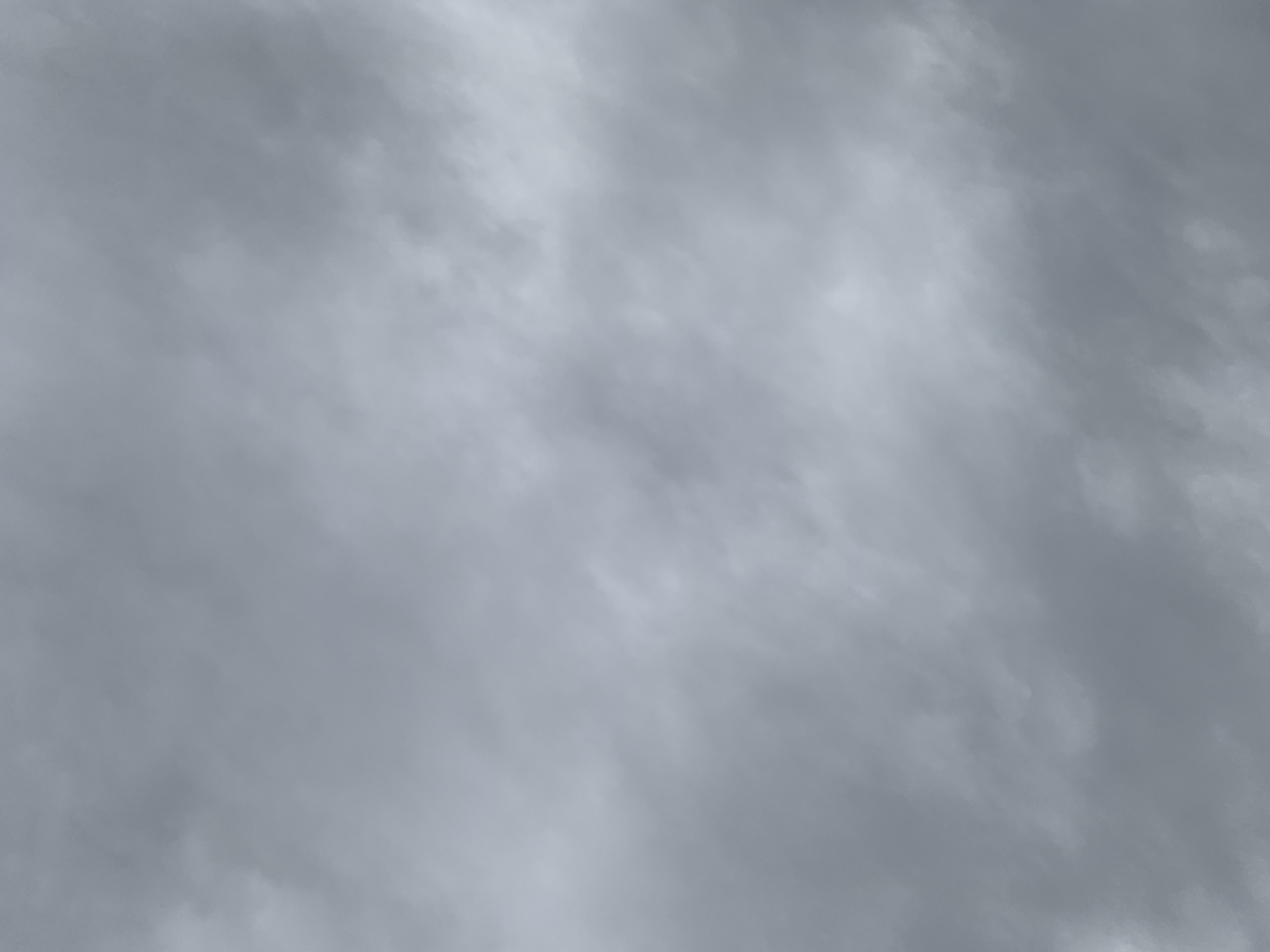 The image is a close-up, full-frame photograph of an overcast sky. The clouds are various shades of gray, with some lighter, almost white areas indicating thinner cloud cover or the presence of sunlight diffused through them. The texture of the clouds appears soft and diffused, typical of a cloudy day. There are no discernible features of Lviv, Ukraine, or any other identifiable landmarks, people, or objects in the image. The focus is entirely on the atmospheric conditions of the sky.
