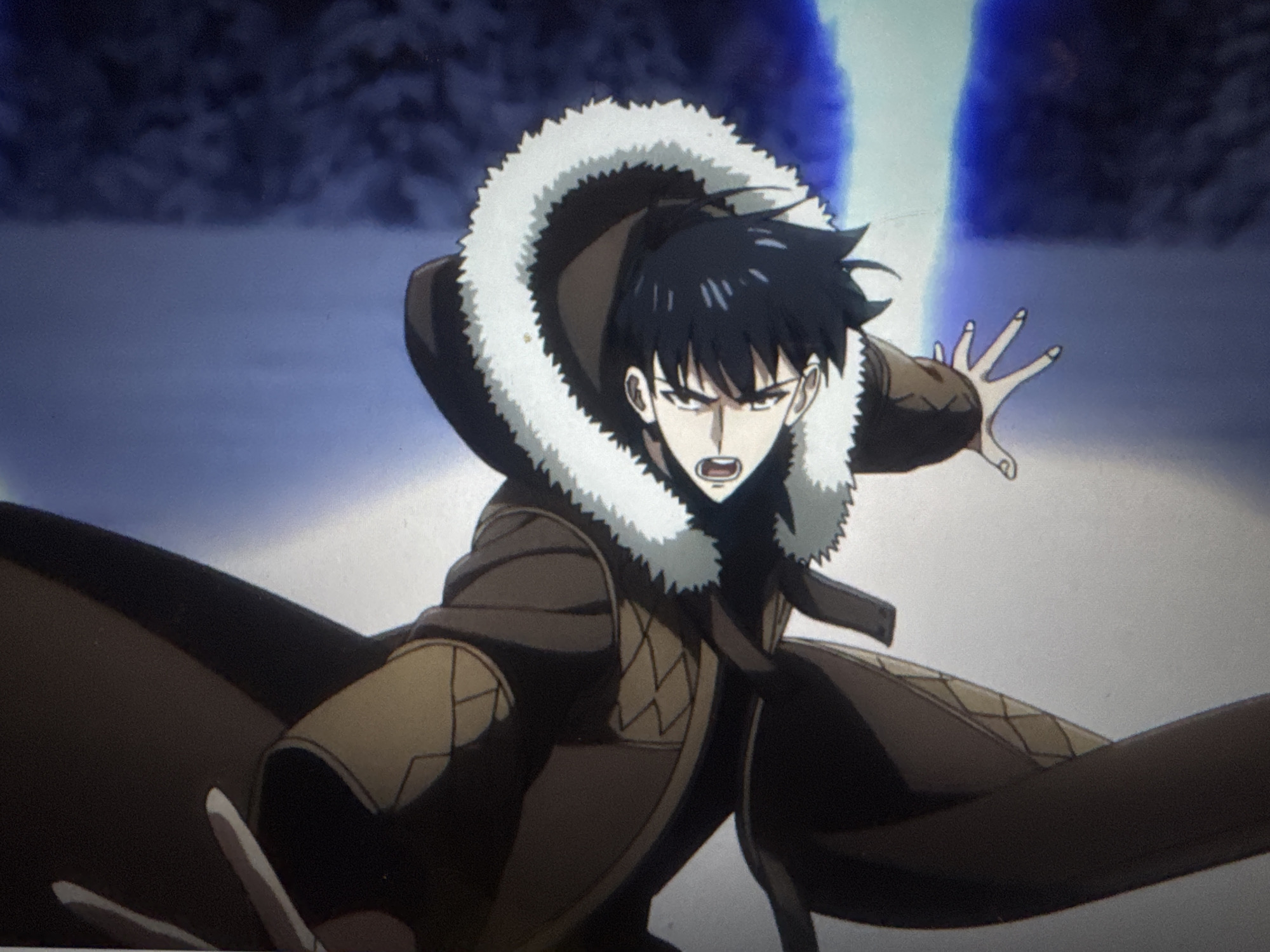 An anime character with black hair and a brown coat with a white fur collar is depicted in a dynamic pose, hand outstretched, against a blurred snowy or icy background. The character has an intense expression. The scene appears to be in a snowy location.