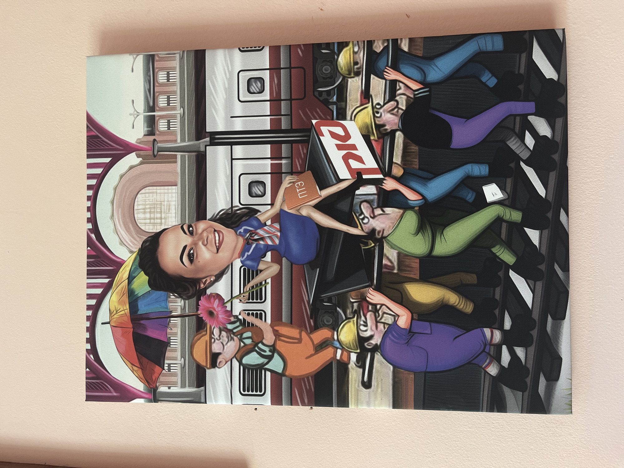 The image is a cartoon-style painting of a woman sitting on a cart, being pushed by several cartoon men. The woman is smiling and holding a pink flower and a book. She is wearing a blue dress and a red and white striped scarf. The men are all wearing hard hats and appear to be laborers. They are dressed in various colored uniforms, including purple, green, and blue. They are pushing the cart along train tracks in front of a train. In the background, there is a train station with arched doorways and a rainbow-colored umbrella. The scene appears to be set in a city, possibly Novoaltaysk, Russia, given the presence of what looks like Cyrillic script on the cart. The painting is rendered with bright colors and a bold, graphic style.