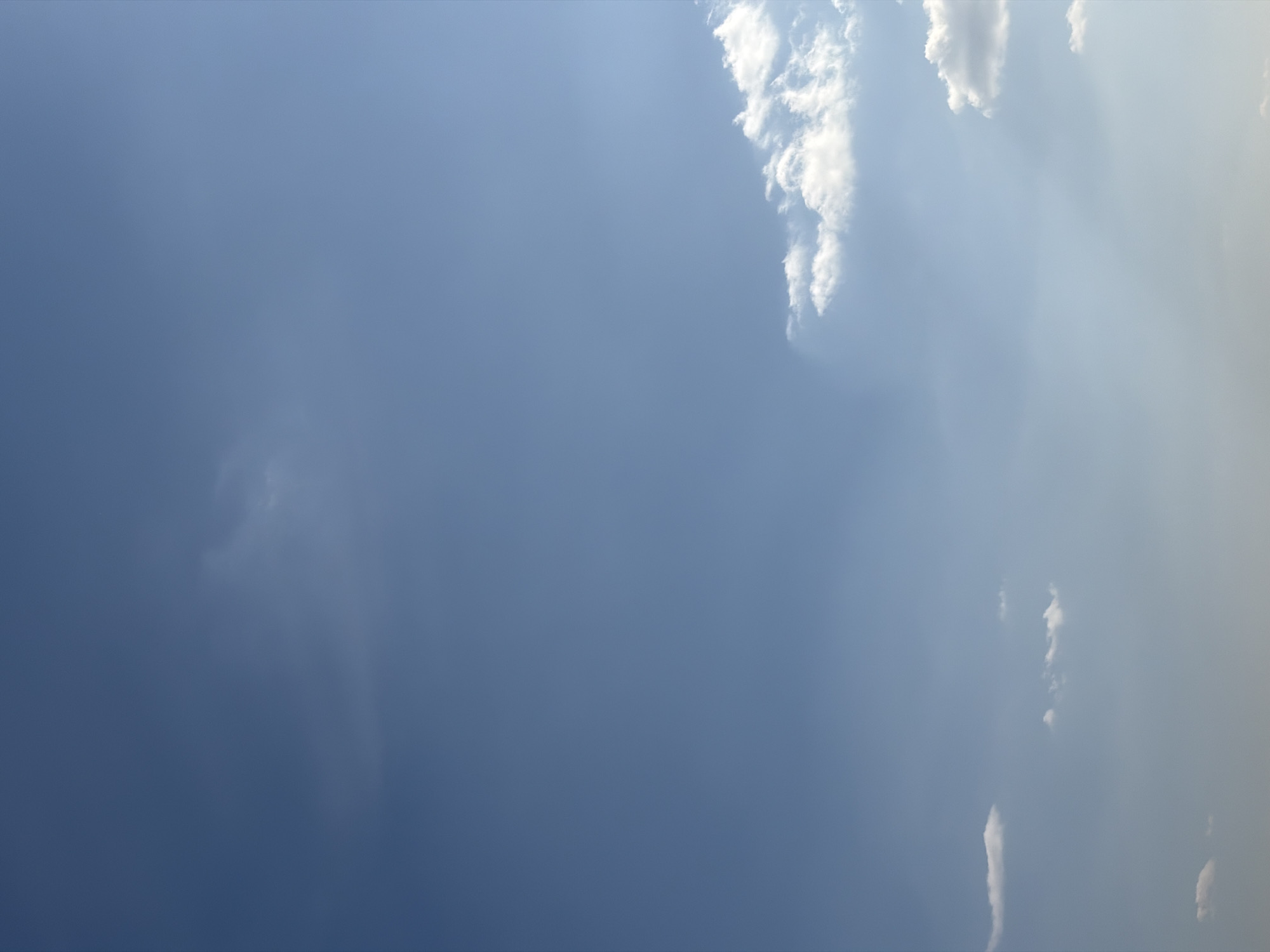 The image shows a sky with clouds. The sky ranges in color from a deep blue on the left side to a lighter, almost white-blue on the right. There are some clouds along the top and right edges of the image. No people or objects are visible. The location is unknown, but stated to be Saint Petersburg, Russia.