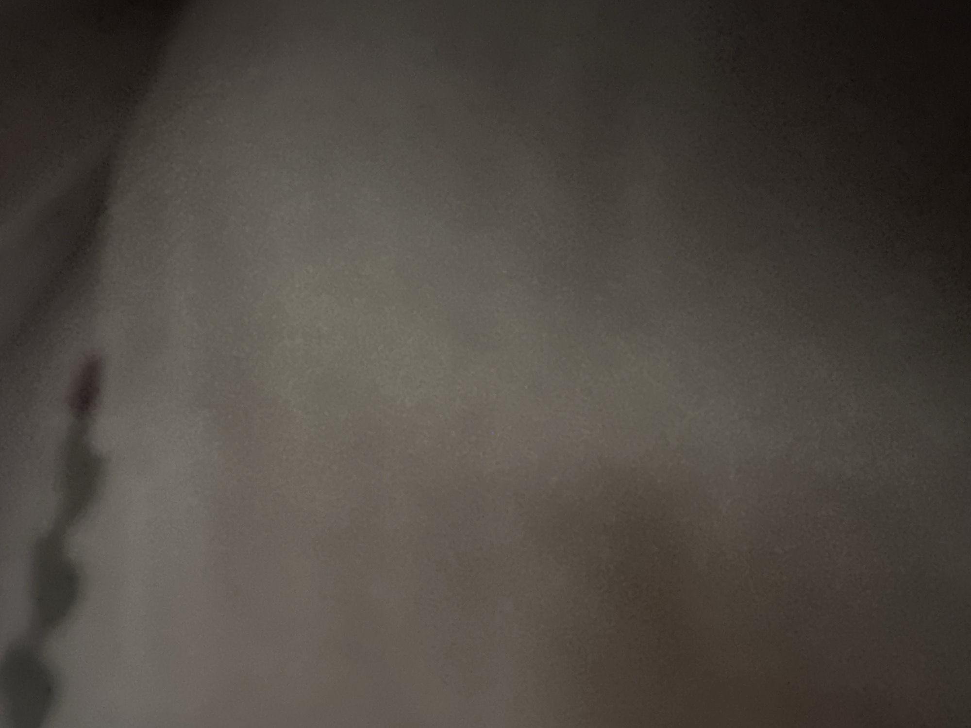 The image shows an out-of-focus, grainy texture, likely a close-up of a fabric or surface. There are no discernible objects, people, actions, or environmental details to establish a location, including if it's within the city of Abu Dhabi, United Arab Emirates.