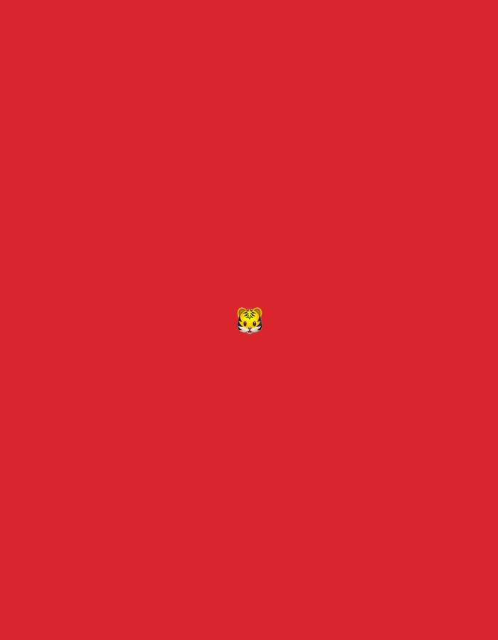 The image is a digital graphic with a plain red background. In the center of the image, there is a small emoji of a tiger's face. The tiger emoji has yellow fur with black stripes, white cheeks, and black eyes and nose. There is no discernible location in Moscow, Russia, as the image is a simple graphic with no contextual elements.
