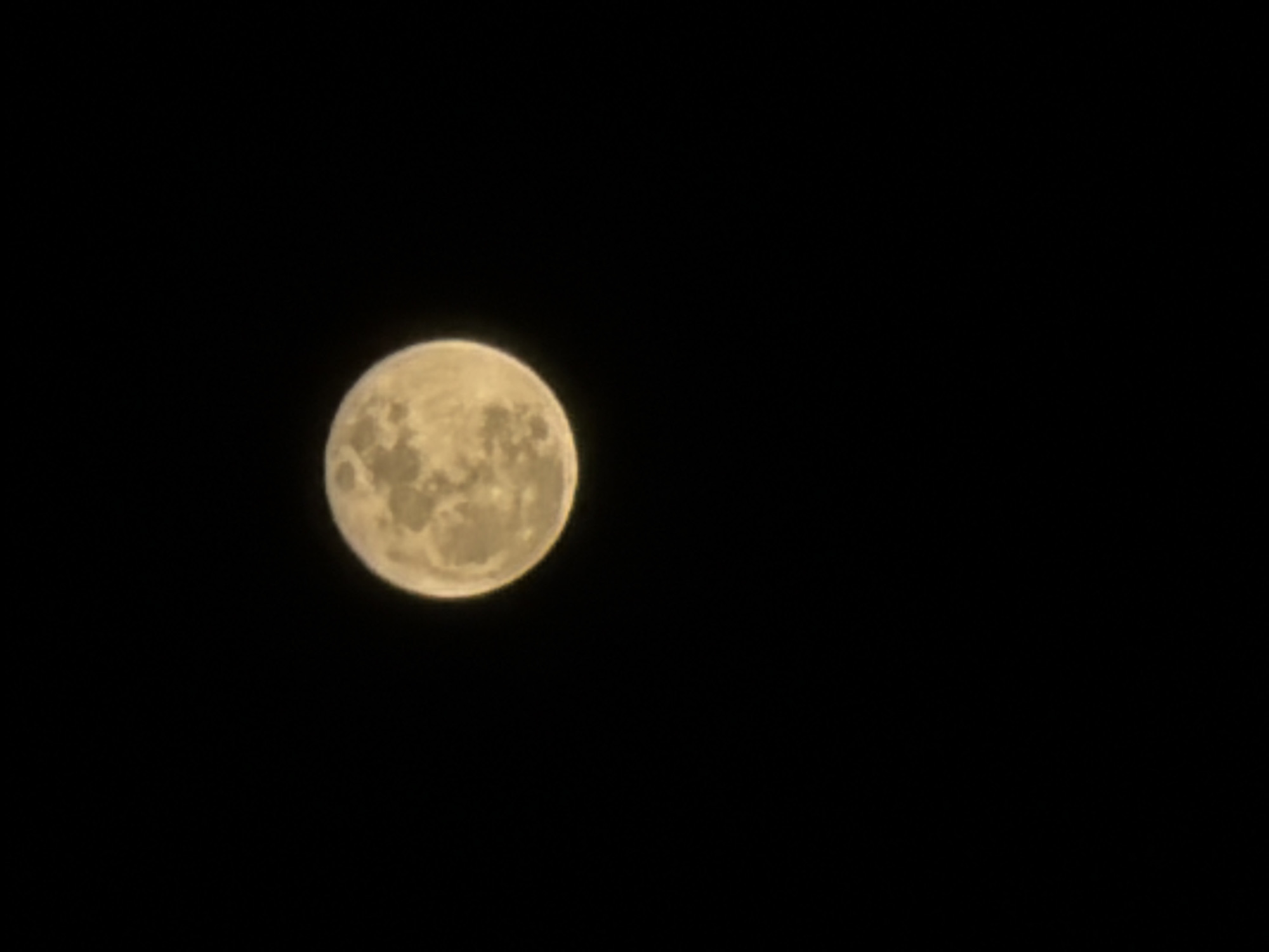 The image features a full moon against a black sky. The moon is located in the lower left quadrant of the frame. There is no other information about the location or time of the photo.