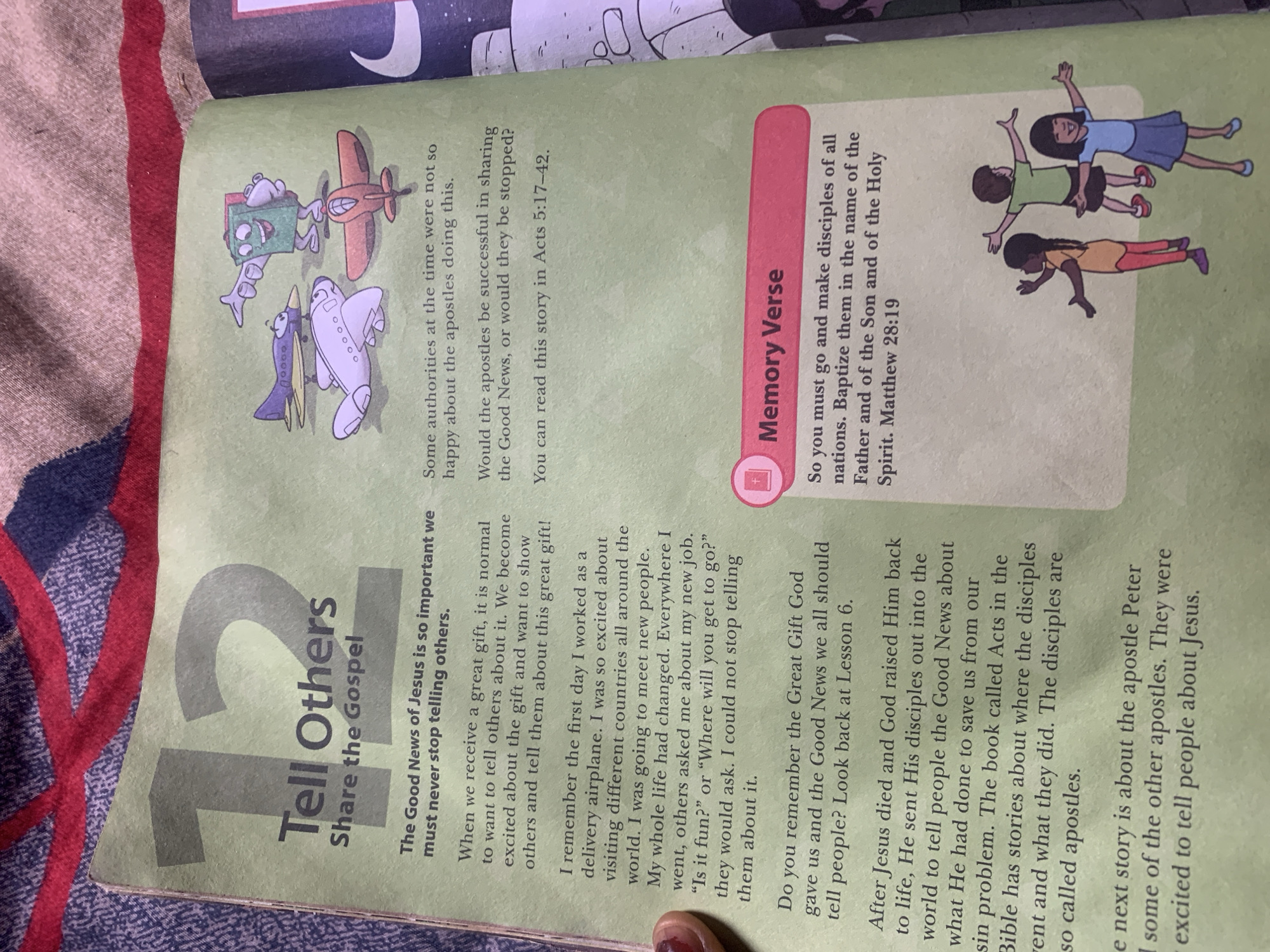 The image shows an open book with text and illustrations. The left page has a large "12" followed by the title "Tell Others" and a subtitle "Share the Gospel". Below this, there is text discussing the importance of sharing the Good News of Jesus. On the right page, there is an illustration of three airplanes and a book-like character with arms and legs. Below this, text discusses authorities at the time and the success of the apostles in sharing the Good News, referencing Acts 5:17-42. Further down, there is a section titled "Memory Verse" with text from Matthew 28:19. Below the Memory Verse, there is an illustration of three children with their arms outstretched. The background of the image appears to be a patterned fabric. The location in Jauro Yinu, Nigeria is not present in the image.
