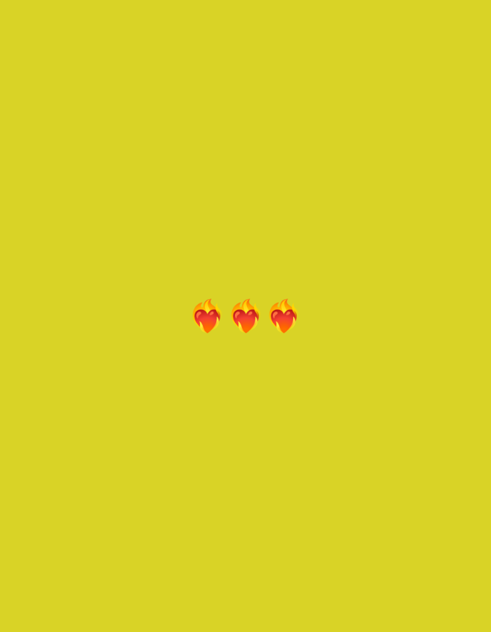 The image is a flat lay against a plain yellow background. Centered horizontally and vertically, there are three small emoji symbols of a heart on fire. The background is a uniform, bright yellow, suggesting a simple digital graphic or a minimalist design rather than a real-world scene. There are no elements present that indicate a specific location in Jenu, Indonesia.