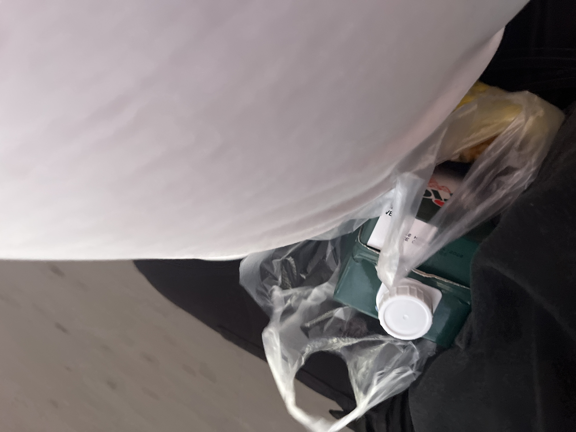 A plastic bag contains a green box with a white cap. The scene appears to be indoors. Juan Griego, Venezuela is not discernible from the given image.