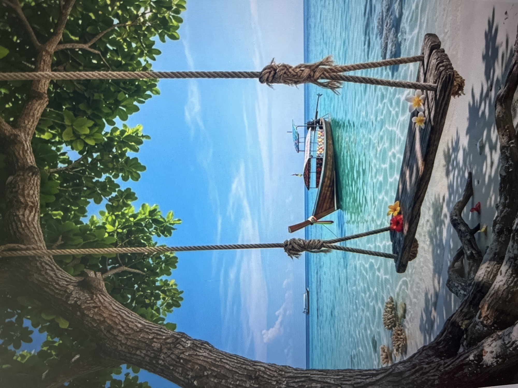 A wooden swing hangs from a tree overlooking a turquoise ocean with a longtail boat in the distance. The swing is made of weathered wood and hangs by thick ropes tied to the branches of a large tree with rough bark. Two plumeria flowers, one red and one yellow, are placed on the swing seat, along with two white plumeria flowers. The clear water reveals the sandy bottom and scattered coral pieces. Sunlight casts dappled shadows on the sand. The sky is a clear blue with a few wispy clouds. The scene evokes a sense of tropical tranquility and relaxation.