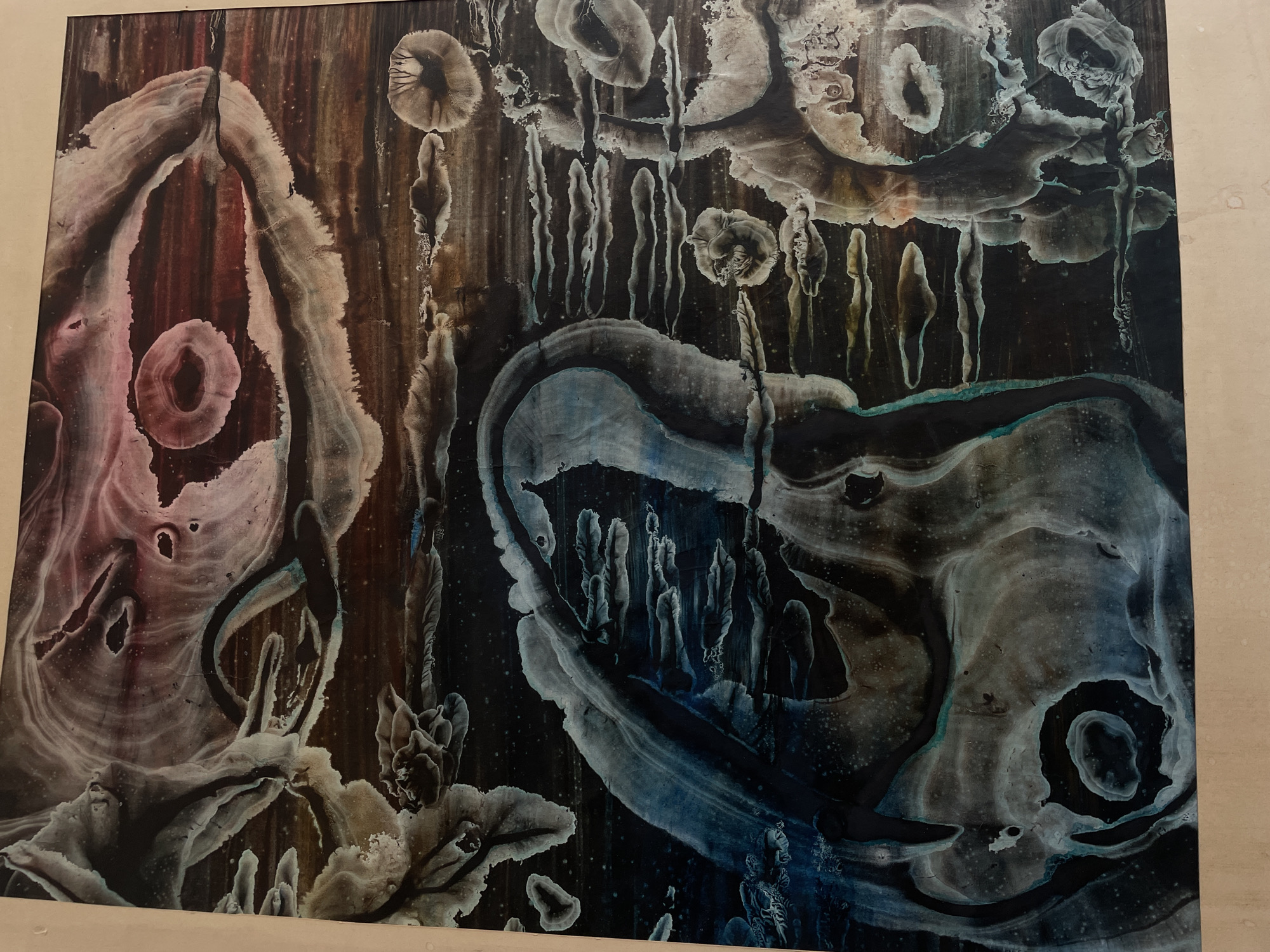 The image shows an abstract painting. The artwork consists of amorphous shapes and patterns in shades of black, brown, grey, pink, and blue. There are no people depicted, and the scene doesn't correspond to any specific location in Saint Petersburg or elsewhere. The artwork has abstract shapes and patterns.