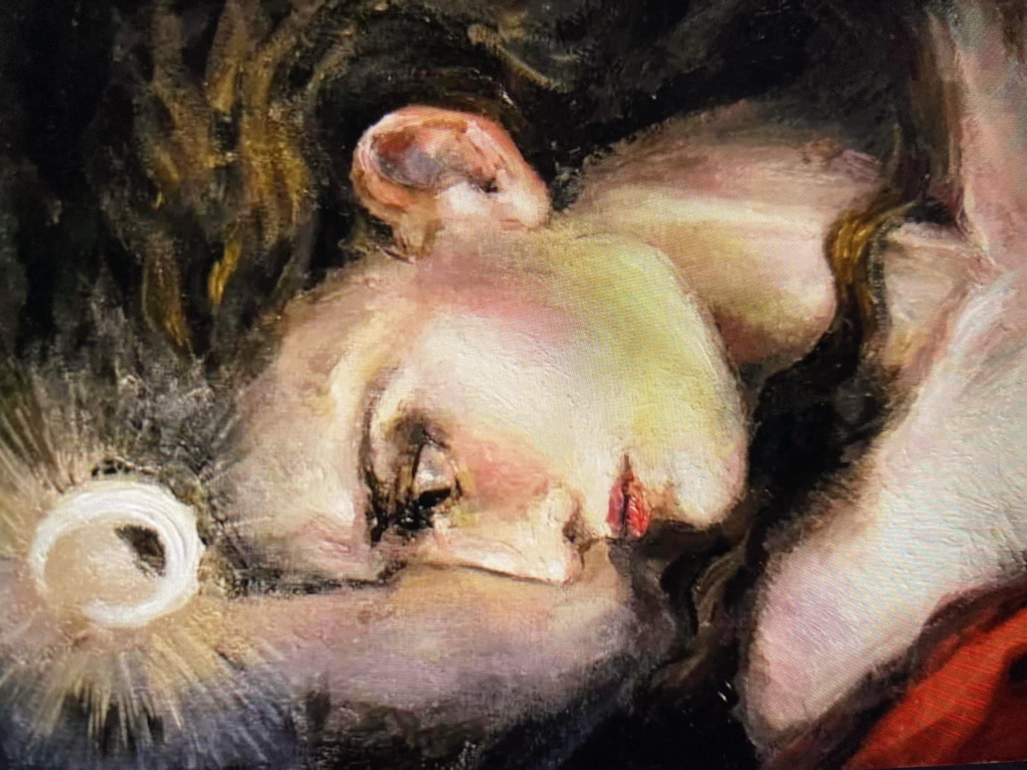 The image is a close-up, oil painting of a woman's profile, looking to the left. She has dark hair that is partially obscured by her face and seems to be flowing. A bright, circular object with radiating lines is positioned above her head, suggesting a halo or celestial body. Her skin is rendered with subtle pink and yellow tones, and her lips are painted red. Her left ear is visible and painted in warm flesh tones. Part of another figure, seen in shadow and rendered in cooler tones, is visible to the left of the woman's face, suggesting an embrace or close proximity. The painting style is expressive with visible brushstrokes. The background is dark and abstract, with hints of brown and black. The location of this artwork within the city of Unknown, Unknown is not determinable from the image itself.