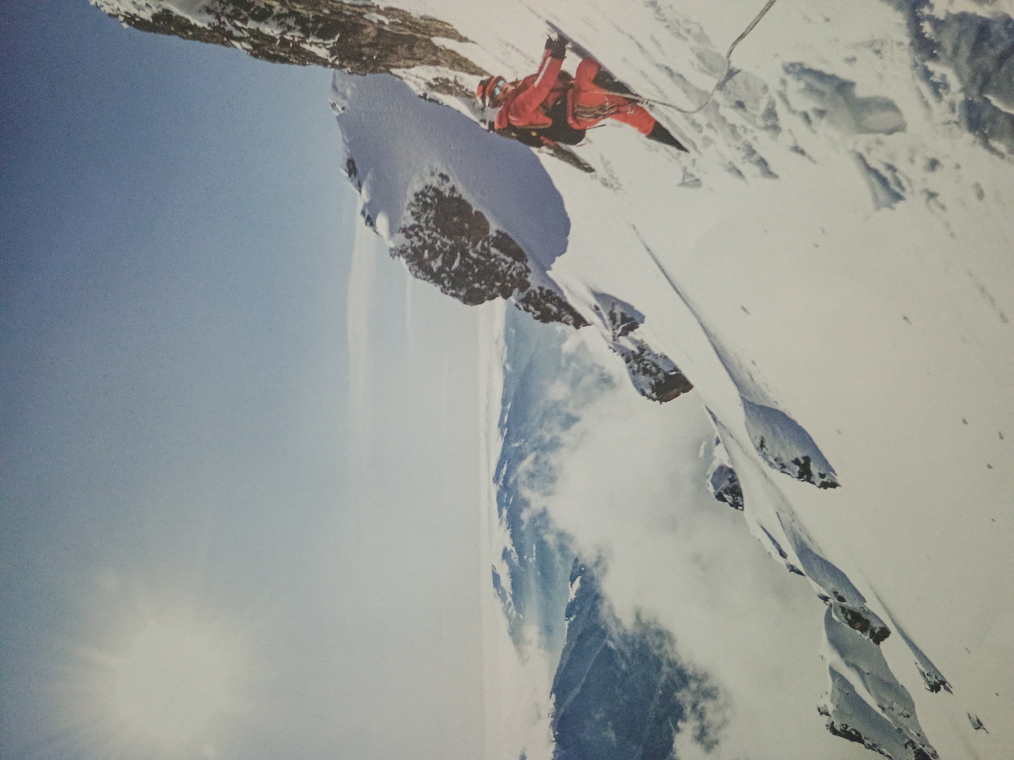 A photograph shows a mountain climber in red gear scaling a snow-covered mountain peak. The climber is positioned on a rocky outcropping. The sky is visible in the background.