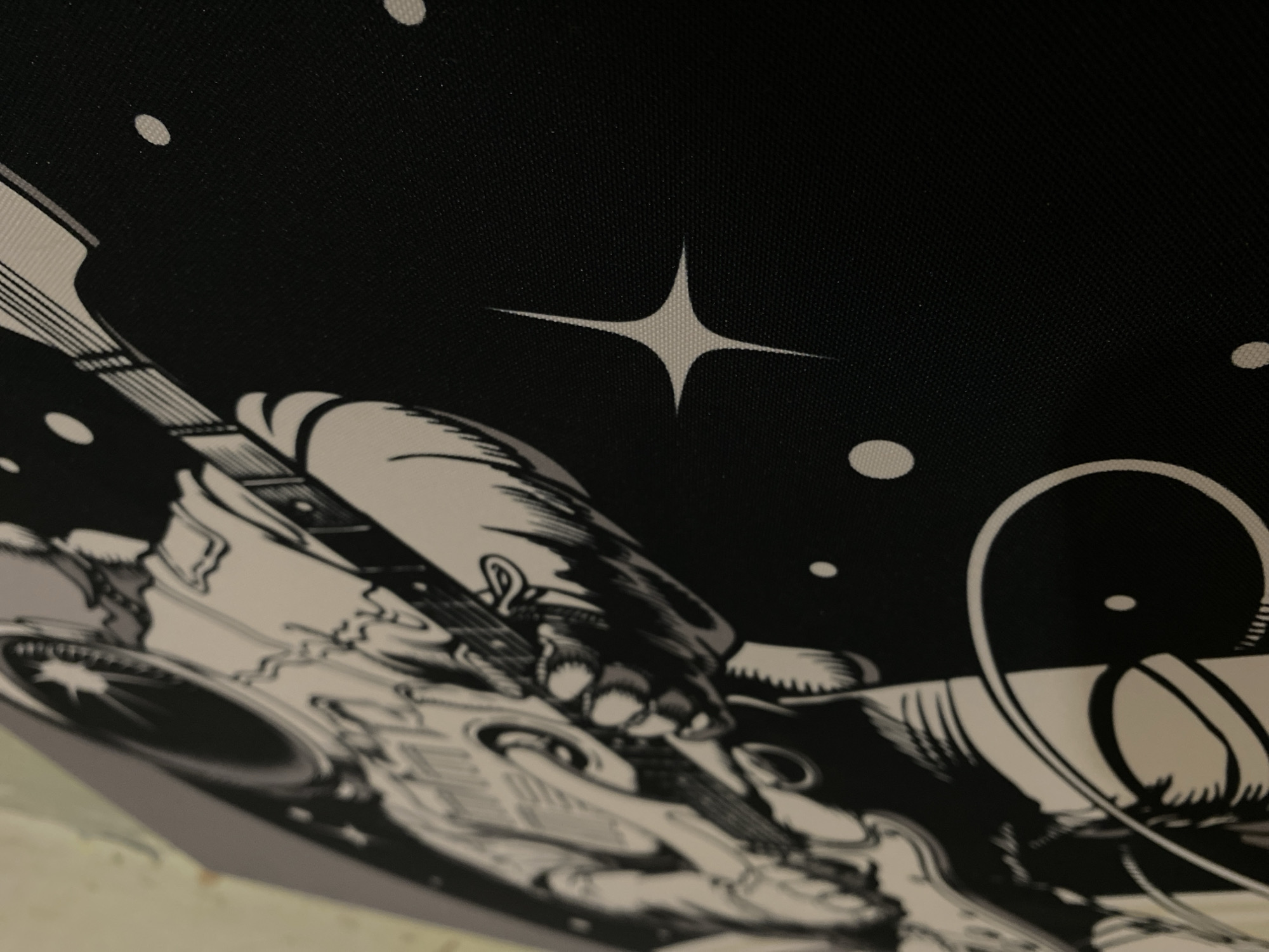 The image is a close-up of a black and white drawing. The drawing depicts a cartoon astronaut wearing a spacesuit, playing an electric guitar. The background is black with white dots and a star. The image does not contain information about Votkinsk, Russia.