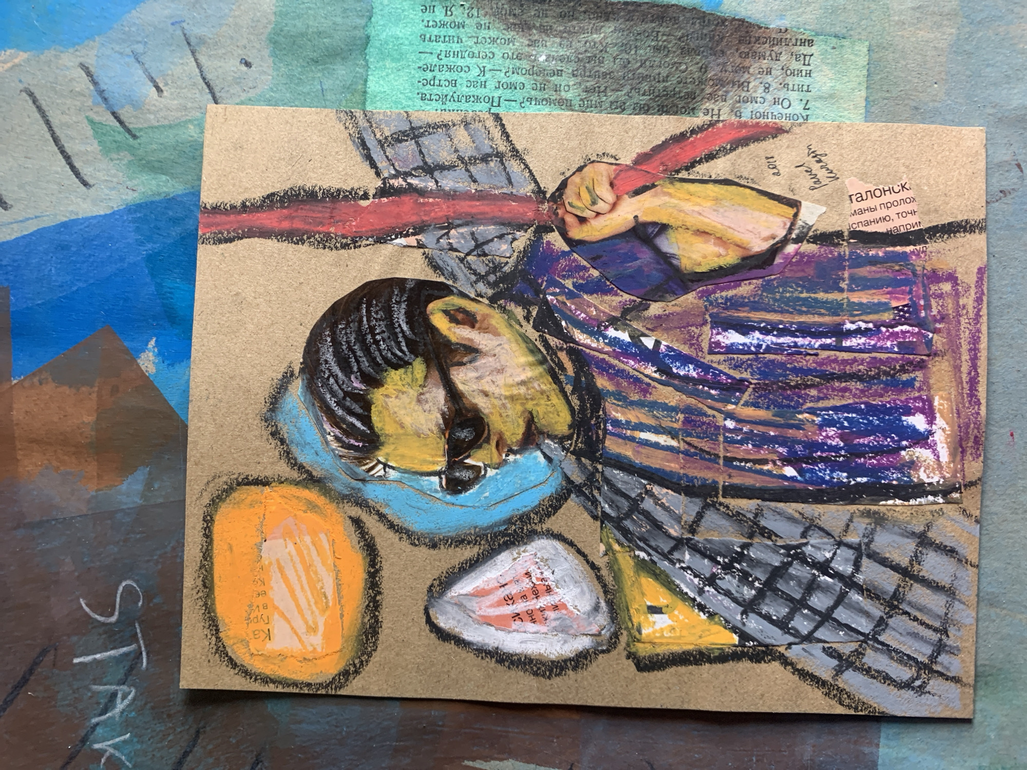 The image is a close-up, eye-level shot of a mixed-media artwork. The central subject is a stylized portrait of a person rendered in oil pastels on a piece of brown cardboard. The person is depicted wearing sunglasses and a patterned garment, with a red vertical element behind them. Abstract shapes in orange and blue are positioned around the subject's head. To the left of the main portrait, there is a white, tear-drop shaped element with red markings inside. The artwork is layered over other torn paper elements with text and abstract color blocks, creating a collage effect. The background appears to be a textured surface, possibly paper or canvas, with visible brushstrokes and splashes of blue and green paint. Text elements are visible on the collage layers, some appearing to be in Russian. The overall impression is one of a vibrant and expressive artistic creation. There is no discernible depiction or reference to the city of Sergeevo, Russia.