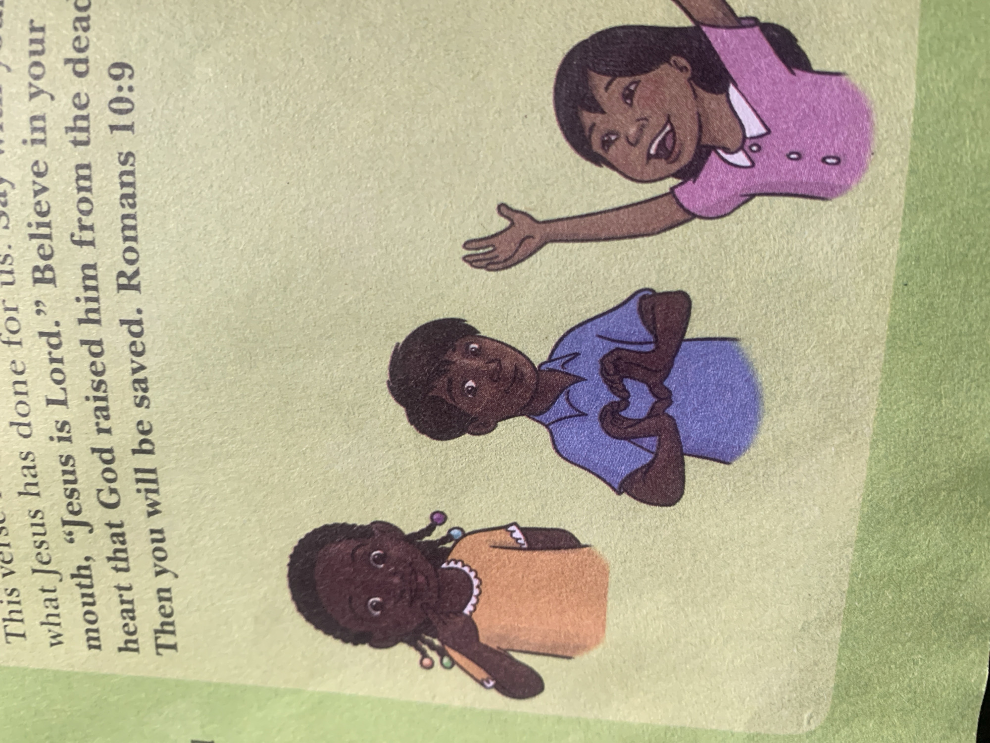 The image shows an illustration of three children on a light green background. The top portion of the image contains text printed in black. The first child on the left is a girl with dark skin and braided hair adorned with colorful beads. She is wearing an orange t-shirt and has her right hand raised towards her face. In the center, a boy with dark skin is wearing a blue shirt and has formed a heart shape with his hands over his chest. To the right, another child, a girl with dark skin, is wearing a pink shirt with a white collar and two buttons. She has her arms raised and her mouth open as if speaking or singing. The text in the upper portion of the image appears to be from a religious text, mentioning Jesus and salvation. The image does not contain any identifiable landmarks or contextual clues that would place it in Jauro Yinu, Nigeria.