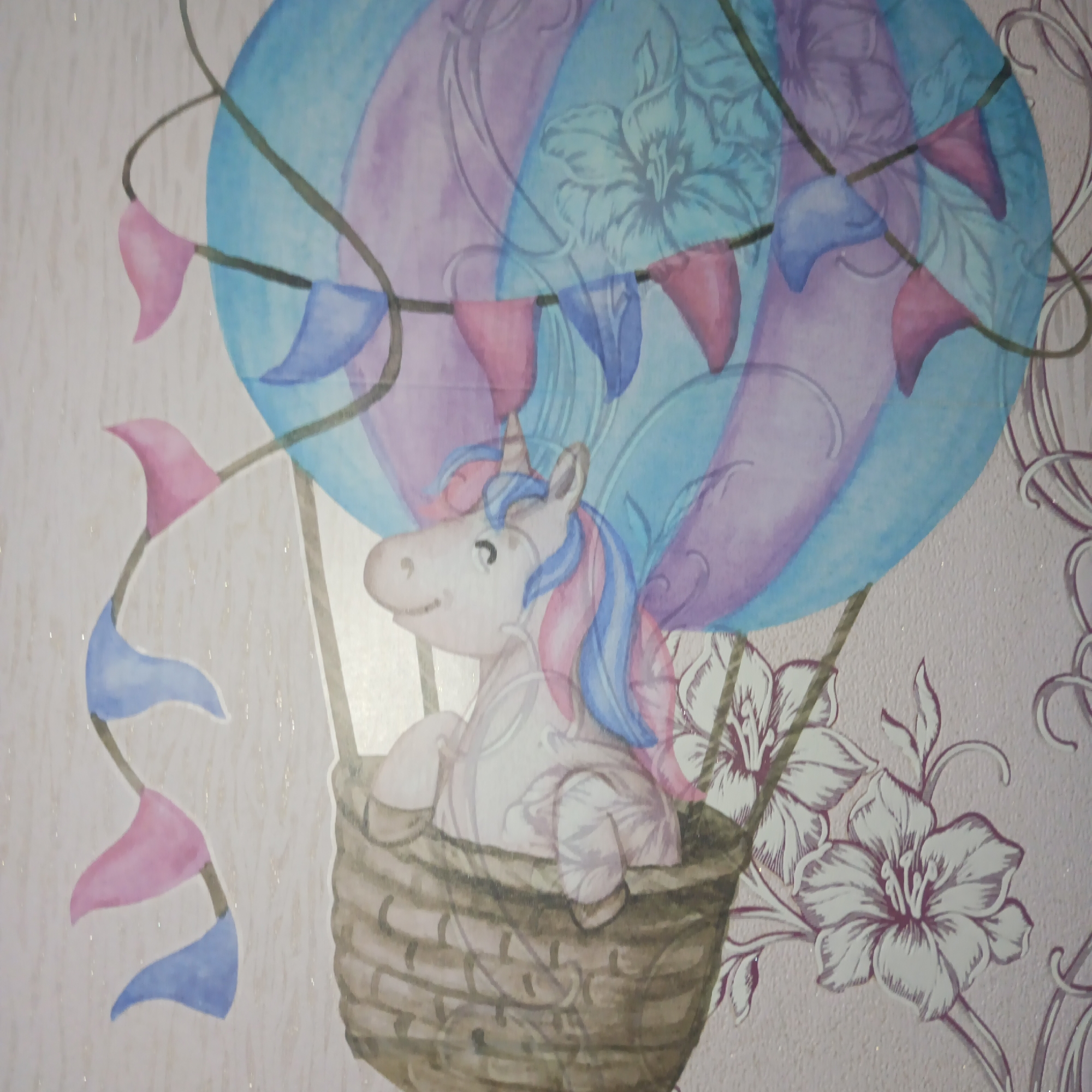 The image shows a watercolor painting of a unicorn riding in a hot air balloon. The unicorn is in a wicker basket attached to the balloon. The balloon is decorated with a string of blue and pink pennants. The background is decorated with floral designs. There is no contextual evidence to link the image to the city of Chaikovsky, Russia.