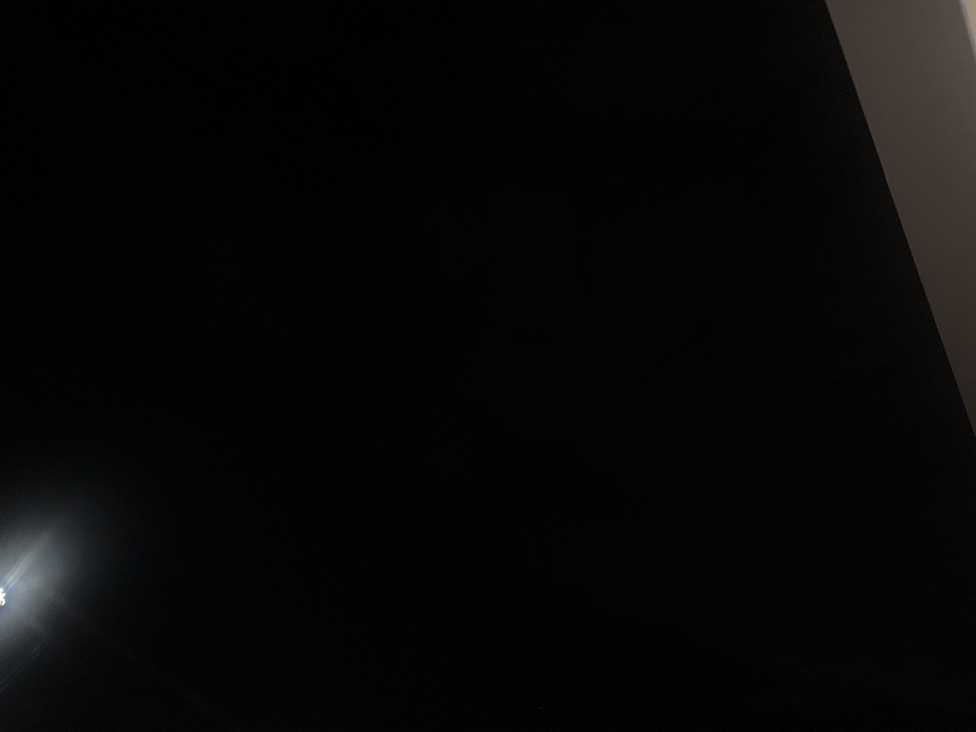 The image shows a street lamp in Boreti, Montenegro. The street lamp is on and is illuminating the surrounding area. The sky is dark, and there are no other visible objects in the image. The street lamp appears to be made of metal and has a white light.