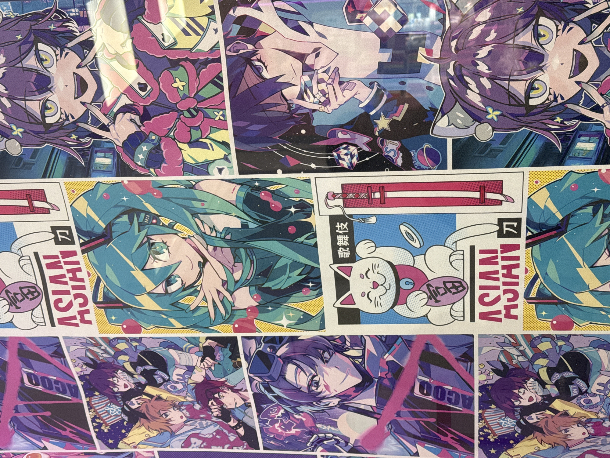 This image is a close-up shot of a printed surface featuring various anime-style illustrations arranged in a collage or comic book format. The artwork appears to depict multiple characters in vibrant, stylized designs. Some panels also include graphic elements, Japanese text, and English text. There are anime-style illustrations of female and male characters. Elements of Japanese culture can be observed, such as a "maneki-neko" (beckoning cat), and what seems to be a sword. The general impression is of a modern, stylized composition, probably on paper or canvas. It cannot be determined that the image was taken in the city of Votkinsk, Russia.