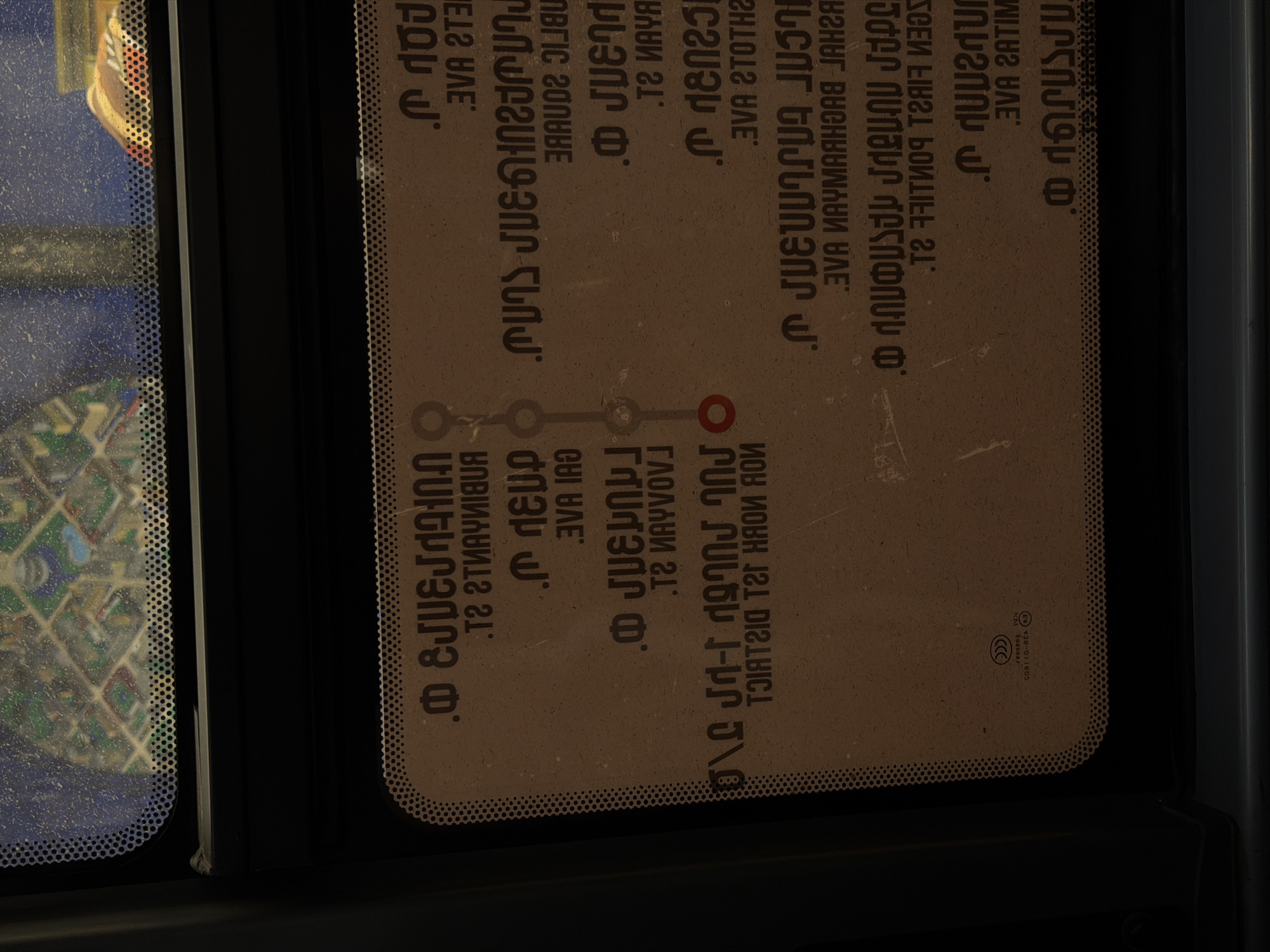 This image shows a sticker inside a public transport vehicle (likely a bus or metro) in Yerevan, Armenia. The sticker displays a route map of the Yerevan Metro in Armenian script. The map outlines different stations and connections within the metro system. The image includes the names of the stations and other details about the system, all written in Armenian. The sticker is affixed to a glass surface within the vehicle, suggesting it's for passenger information and guidance.