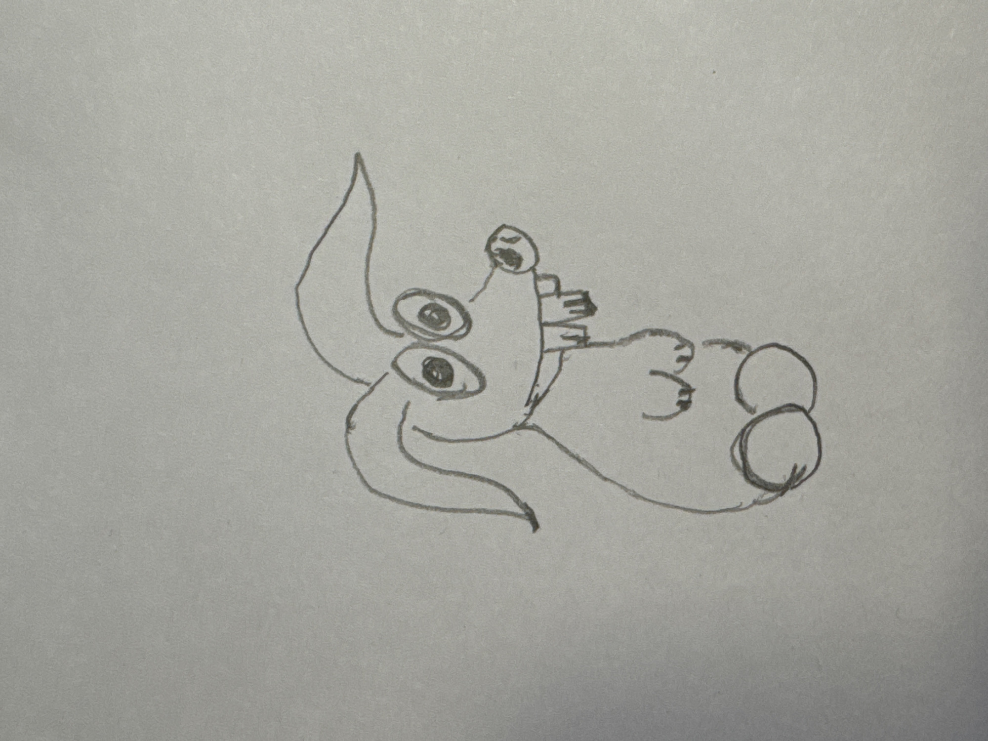 A crude pencil sketch depicts a cartoonish creature with long ears, large circular eyes with dark pupils, a small snout with nostrils, and prominent buck teeth. The creature has two small arms and two circular feet. The drawing is rendered on a plain, grey background. There is no indication of a location in Перовское сельское поселение, Ukraine.