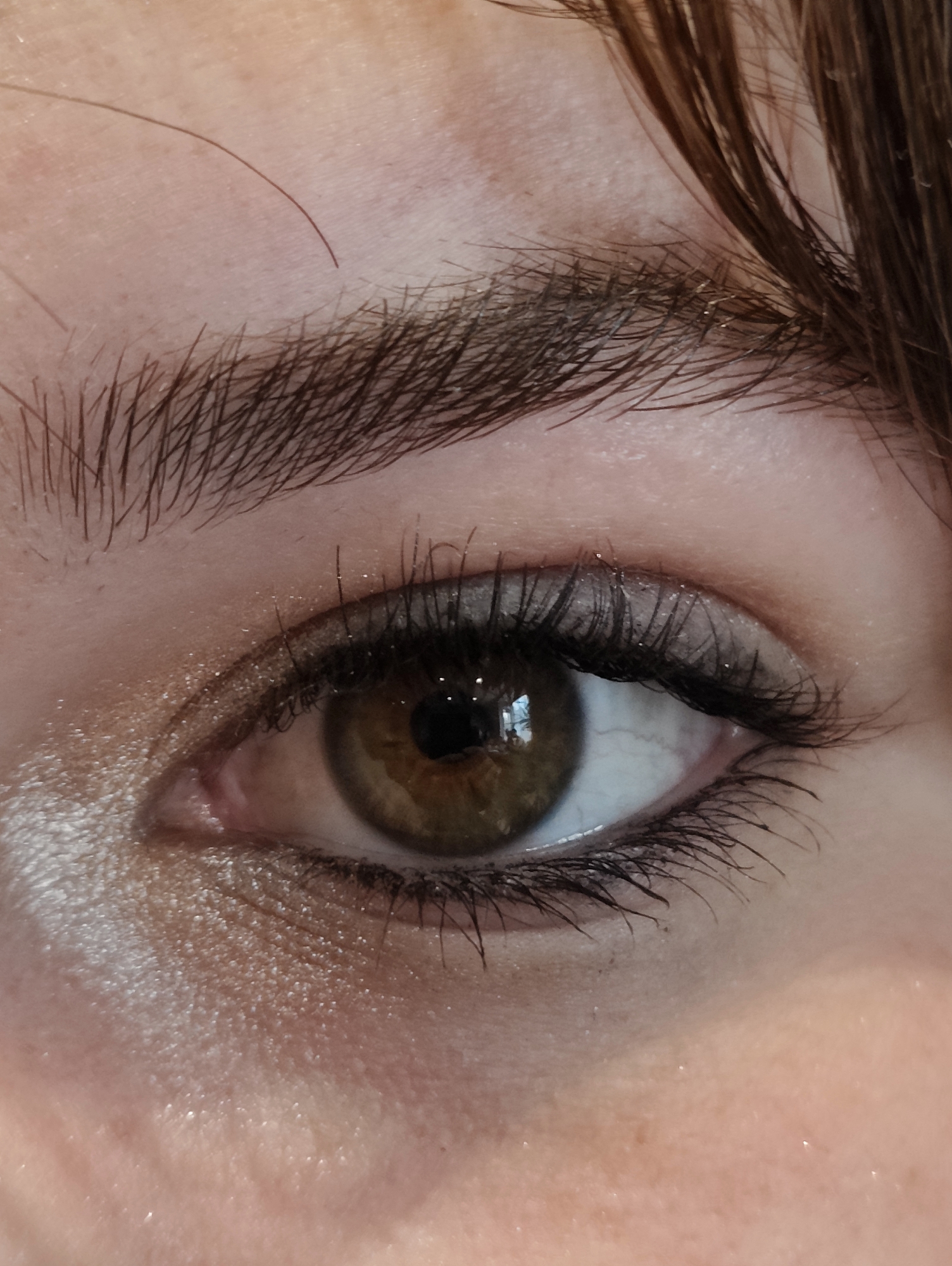 A close-up photograph shows a human eye. The iris is brown with a dark pupil. Eyelashes frame the eye, with dark eyeliner applied along the upper and lower lash lines. The eyebrow is dark brown and slightly arched. Skin is visible surrounding the eye, with light eyeshadow and some skin texture. The image does not depict a location, person, action, or interaction, nor does it allow for the identification of a specific place like Ipswich, United Kingdom.