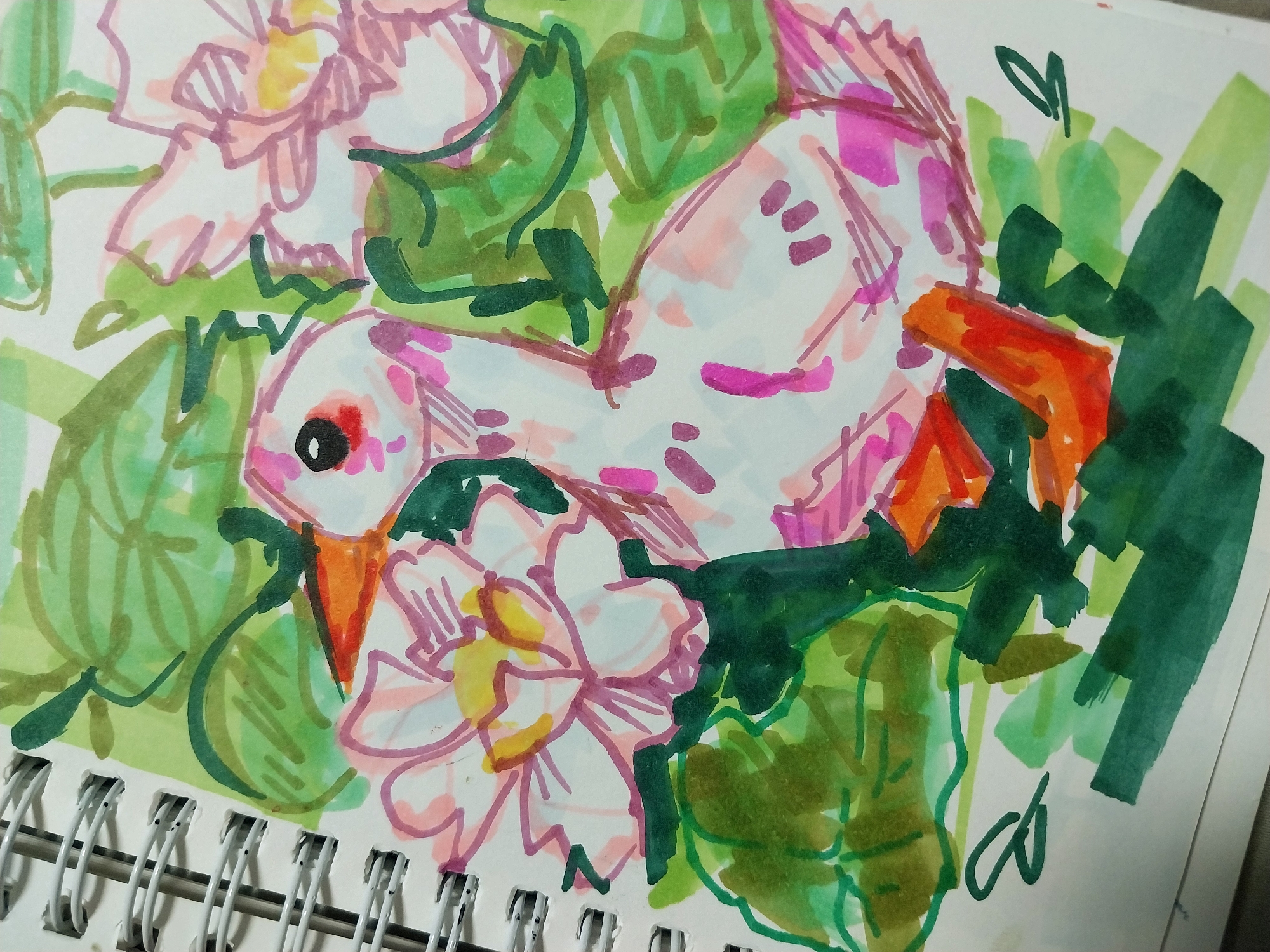 The image is a close-up, eye-level, overhead shot of a marker drawing on white paper, which appears to be part of a sketchbook bound by a white spiral. The drawing depicts a stylized duckling amidst pink lotus flowers and green foliage. The duckling is white with pink splotches, an orange beak and feet, and a black eye with a red highlight. The lotus flowers are sketched in outlines of pink and filled with pale pink and yellow. Green markers are used for the leaves and stems, creating a sense of depth and framing. The overall style is loose and impressionistic, with visible marker strokes and overlapping colors. The background is white paper. There is no identifiable location within Gimhae-si, South Korea, as the image solely focuses on the artwork.