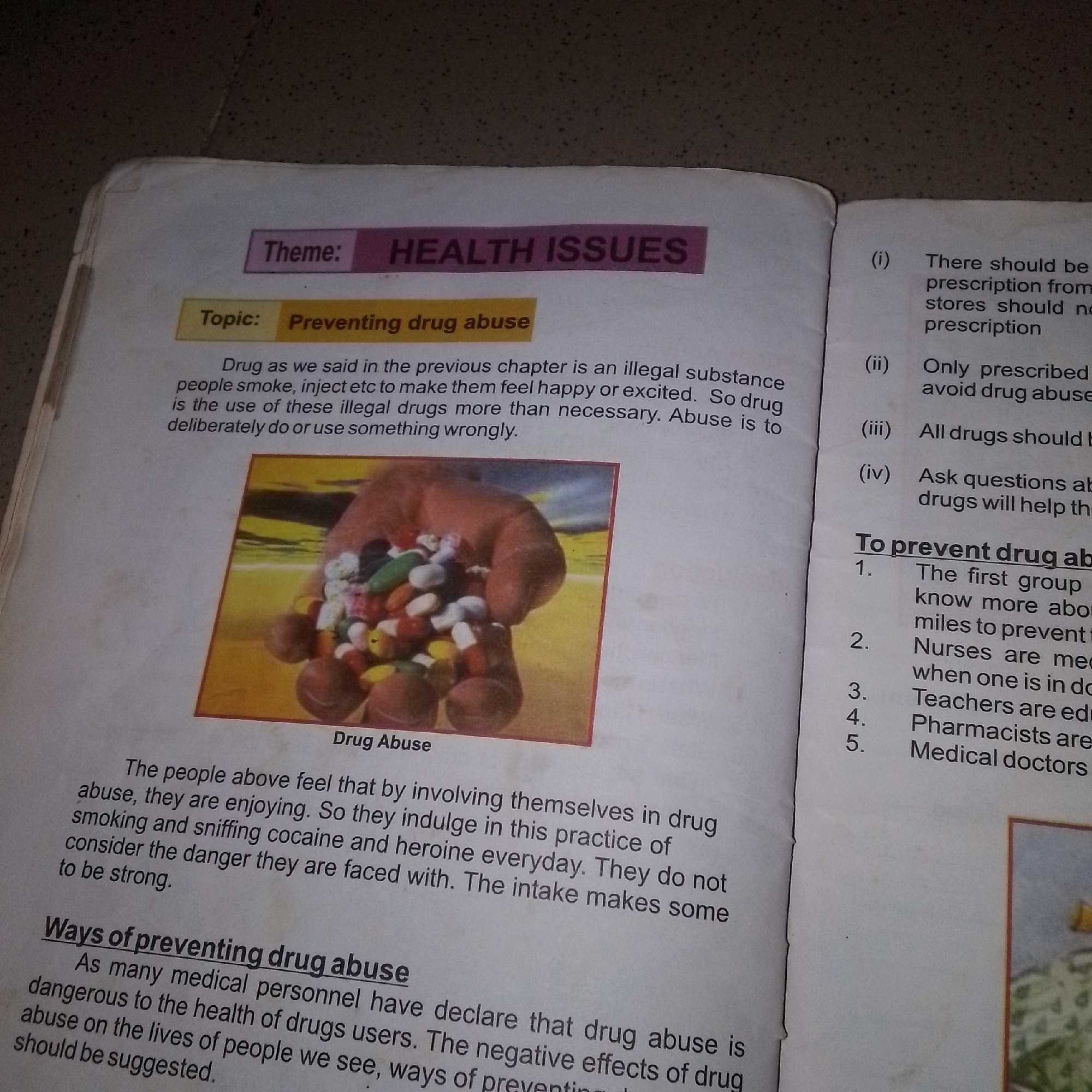 The image displays a page from a book discussing "HEALTH ISSUES" and specifically focusing on "Preventing drug abuse." The page contains text and an illustration. The text is divided into sections, with a heading "Theme: HEALTH ISSUES" and a subheading "Topic: Preventing drug abuse." Below this, there is a paragraph describing drug abuse. A prominent illustration shows a hand holding a pile of colorful pills and capsules. To the right of the illustration, there is a numbered list titled "To prevent drug abuse," outlining preventative measures. The overall presentation suggests an educational or informational context. The text is written in English. There is no information within the image that indicates the location of Jalingo, Nigeria.