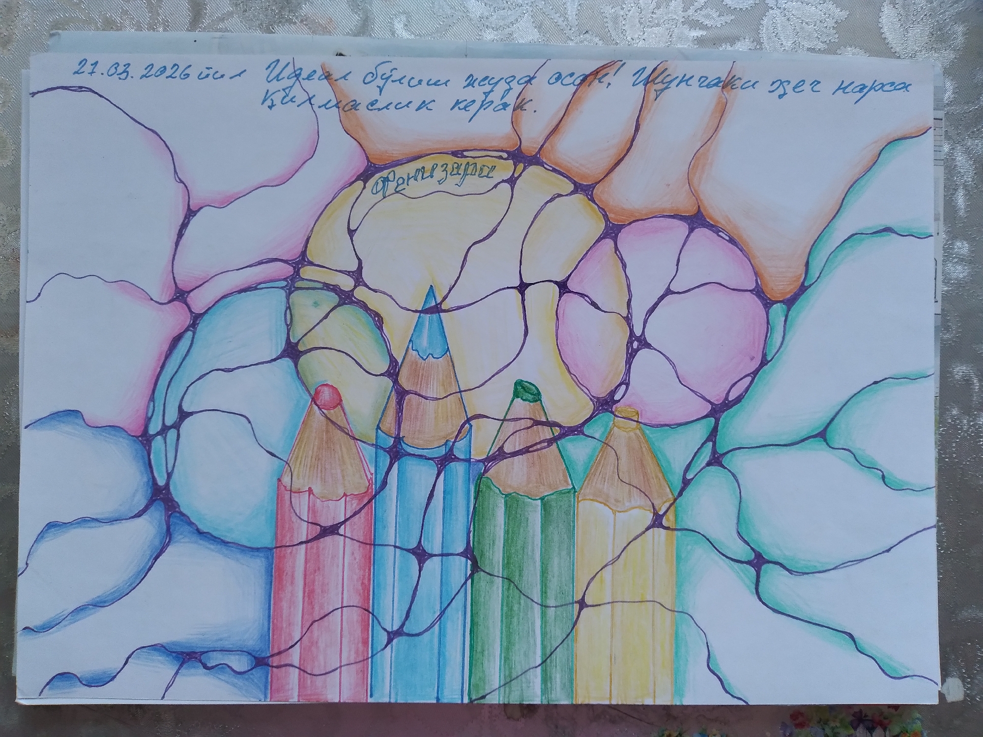 The image is a close-up, slightly angled, overhead view of a drawing on white paper. The drawing features a neurographic art style, characterized by swirling lines and organic shapes filled with various pastel colors, including pink, light blue, yellow, green, and orange. Interspersed within the abstract design are the sharpened points of several colored pencils, suggesting they were used to create the artwork.
There is handwritten text in blue ink on the right side of the drawing. The text appears to be in Cyrillic script. The top line reads "21.03.2026 й." which likely indicates a date. Below this, there is more text that is difficult to fully decipher due to the angle and script, but parts of it seem to be a name or dedication. The script is written vertically along the right edge of the paper.
The drawing itself is centered within the frame, with the white paper extending beyond its edges. The paper is placed on a textured surface, possibly a tablecloth with a floral or lace pattern, which is visible at the bottom and right edges of the image. The lighting appears to be natural and diffused, casting soft shadows and highlighting the colors of the drawing and pencils. There is no indication of the city of Baki, Uzbekistan, or any specific urban environment within the image.