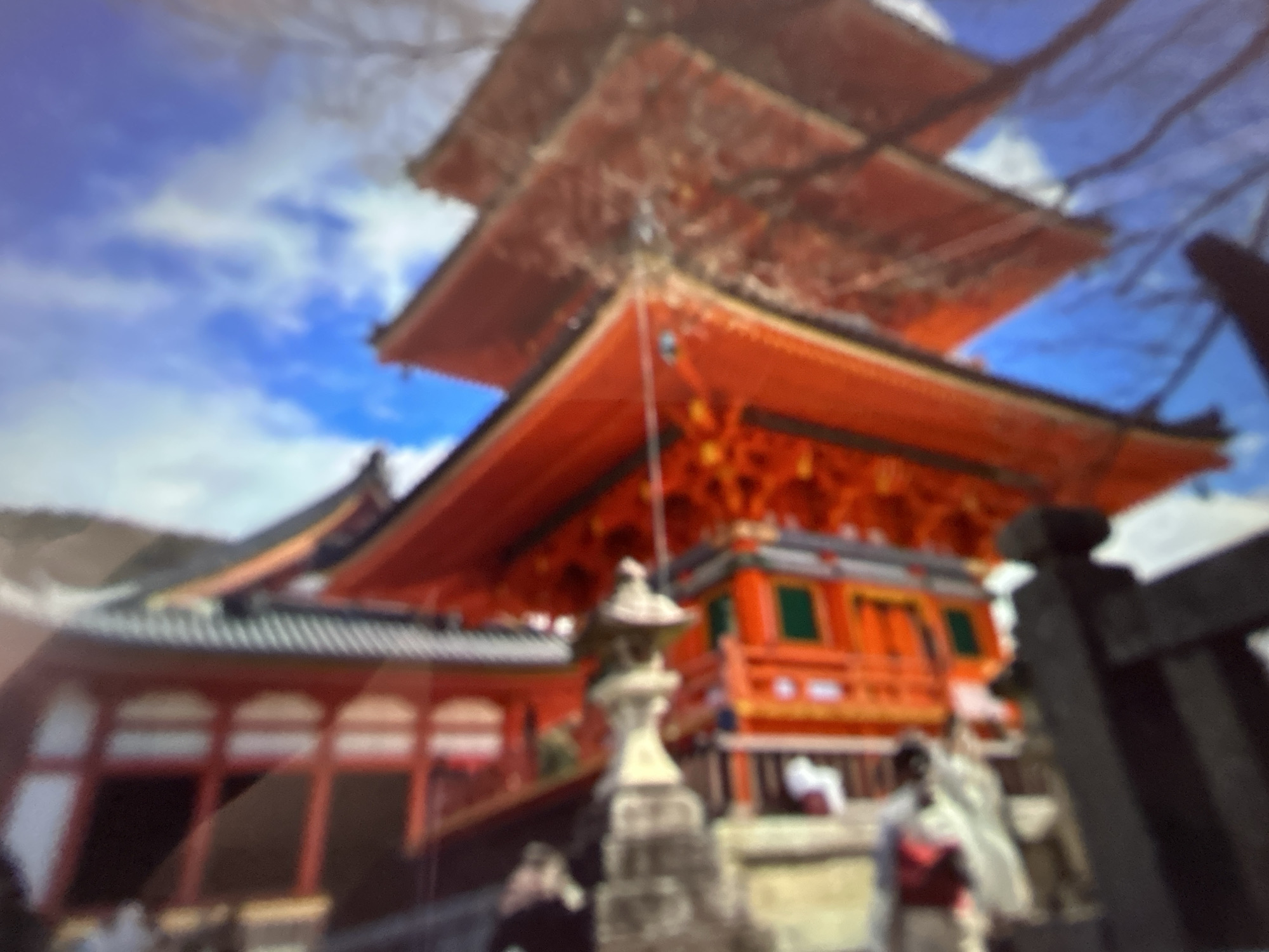 The image shows a distorted view of a red and orange structure with a blue sky in the background. The structure appears to be a building with multiple levels and decorative elements. The image is out of focus, making it difficult to discern specific details. There is no identifiable location in the city of Gelendzhik, Russia.