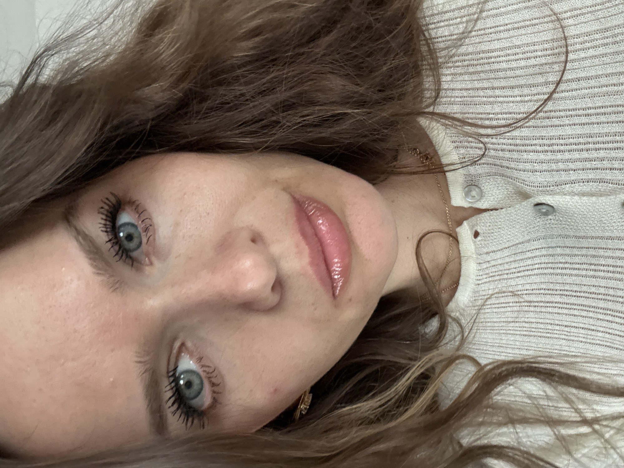 A close-up, slightly rotated, portrait of a fair-skinned woman with brown hair and blue eyes. She has a button-down, cream-colored top on. No identifiable location in Khimki, Russia, is visible in the image.