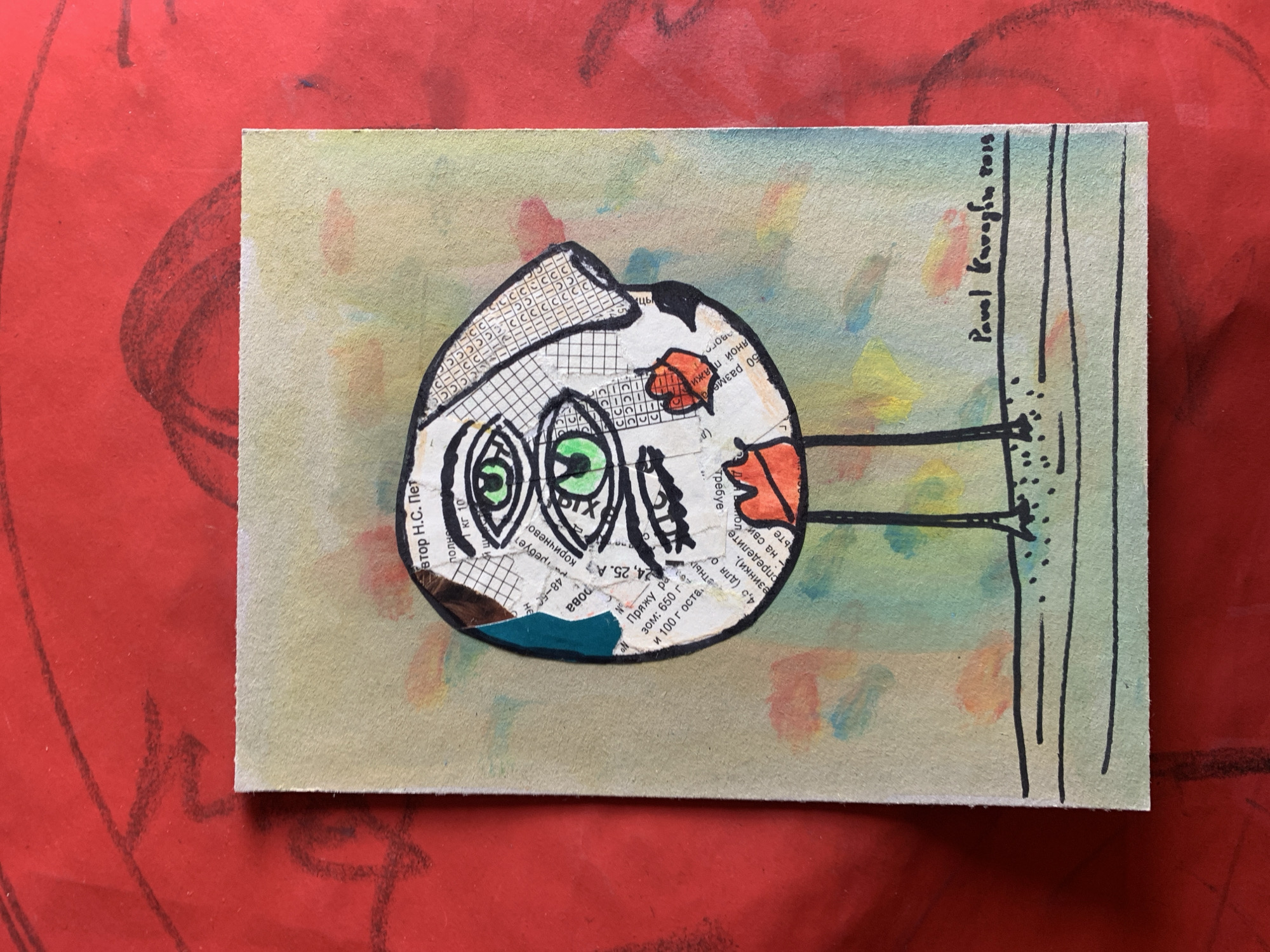 A watercolor and collage artwork depicts a stylized, abstract face with three green eyes and red lips, standing on two thin legs. The face is composed of torn paper fragments, including text and a grid pattern, with a blue and brown tear on the left side. The background of the artwork is a light green with splashes of yellow, orange, and blue watercolor. The artwork is signed "Pavel Karaglu 2015" in the bottom right corner and is placed on a red surface with visible charcoal or pencil markings. The location of Sergeevo, Russia is not discernible from the image.
