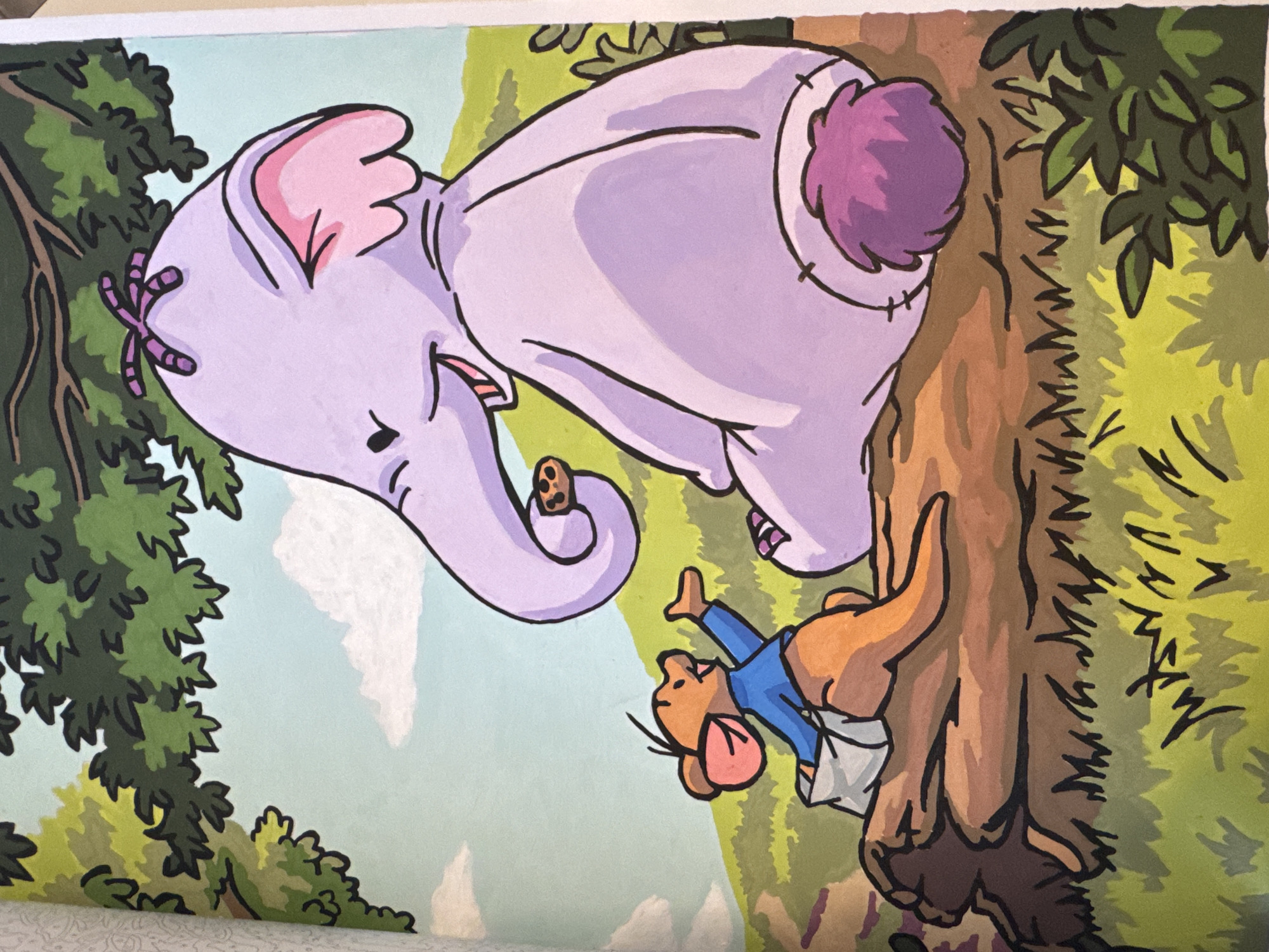 An illustration depicts a purple elephant and a brown kangaroo sitting on a fallen log. The elephant is on the right, facing left, and appears to be eating a cookie from its trunk. The kangaroo is on the left, facing the elephant, and is wearing a blue shirt and a white diaper. The kangaroo has its right arm raised. Both characters are drawn in a cartoonish style with thick black outlines. The background shows green rolling hills under a pale blue sky with scattered white clouds. Lush green foliage and trees are visible, suggesting an outdoor, natural setting. The scene appears to be from a children's book.