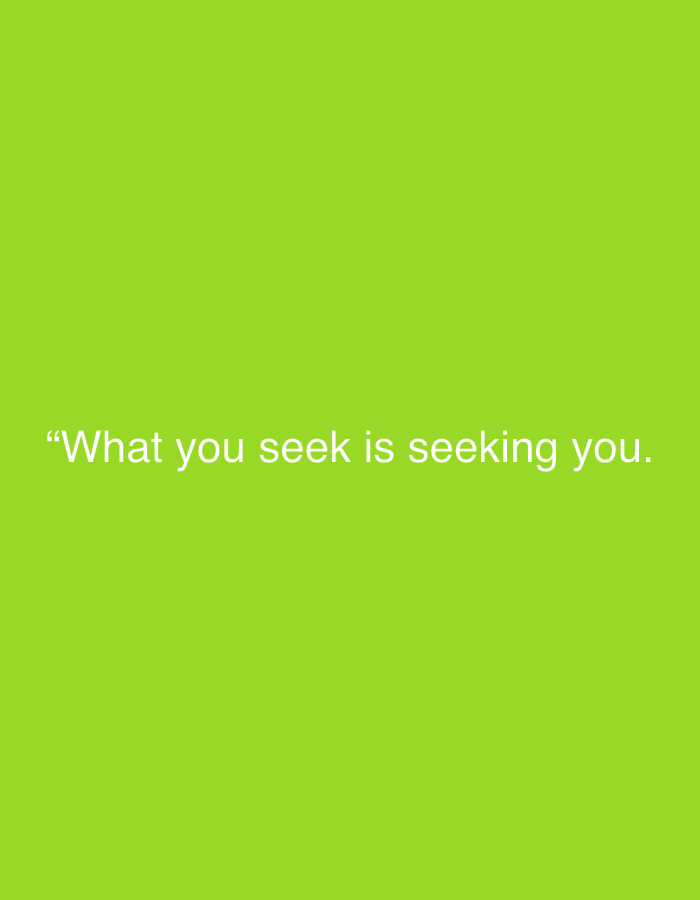 The image displays a solid, uniform lime green background. Centered horizontally and slightly below the vertical mid-point of the frame, there is white text. The text is a quote, enclosed in quotation marks, and reads: "“What you seek is seeking you.”" The font used for the text appears to be a clear, sans-serif typeface.
There are no discernible people, objects, or specific scenes depicted in the image, apart from the colored background and the text. No activity or event is taking place. The image is a static graphic featuring a motivational or philosophical quote. There are no notable details regarding the time of day, weather, or any explicit location cues within the image itself. The overall impression is minimalist and clean, designed to highlight the textual message.