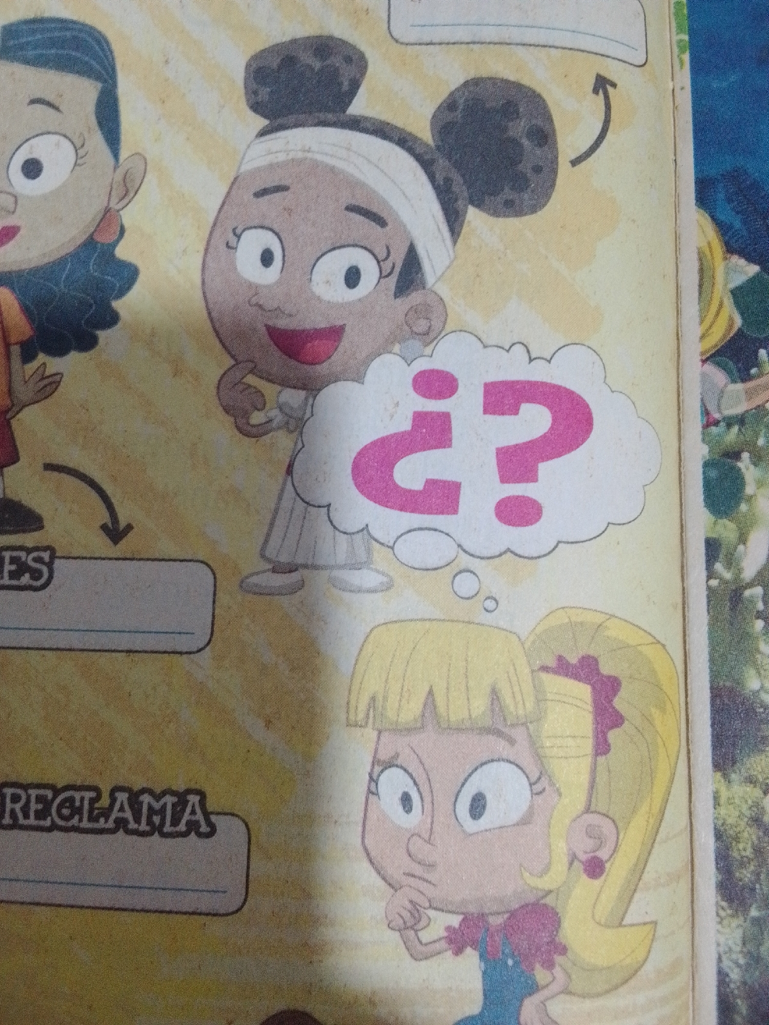 The image displays a cartoon illustration featuring three young girls against a textured yellow background, reminiscent of aged paper. The girl on the left has dark curly hair and wears an orange shirt. To her right, a girl with dark skin and hair styled in two buns, wearing a white dress and a white band around her head, has a speech bubble containing "¿?" in hot pink letters. Below and to the right of this girl is another cartoon, a young girl with blonde hair tied in a ponytail with a pink ribbon, wearing a blue overall dress with a pink ruffled shirt. Her hand is near her chin, suggesting contemplation. A curved arrow points from the girl with buns to a box labeled "ES" and another box below it appears to be a fill-in-the-blank area. Below that, a box displays the word "RECLAMA". The illustration appears to be from a children's activity book or comic. There is no discernible information within the image that would indicate its location in La Tagua, Venezuela.