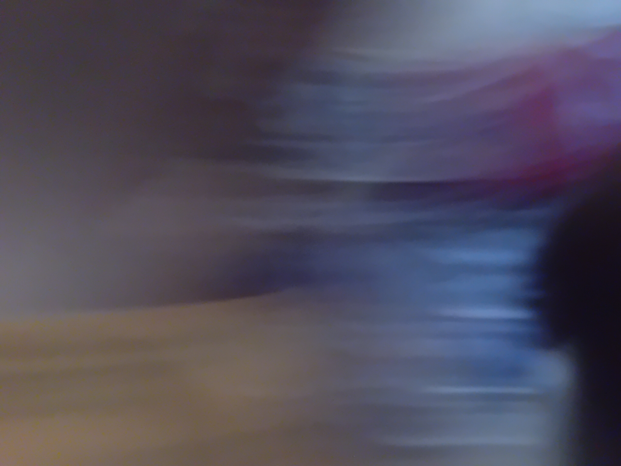 The image shows a blurry, abstract composition of colors and shapes. There are horizontal streaks of light blue, purple, and a muted yellow or brown. The overall impression is of motion blur, suggesting a fast-moving subject or camera shake. There are no discernible people, objects, or specific environmental details that can be identified to place the image in Jauro Yinu, Nigeria.