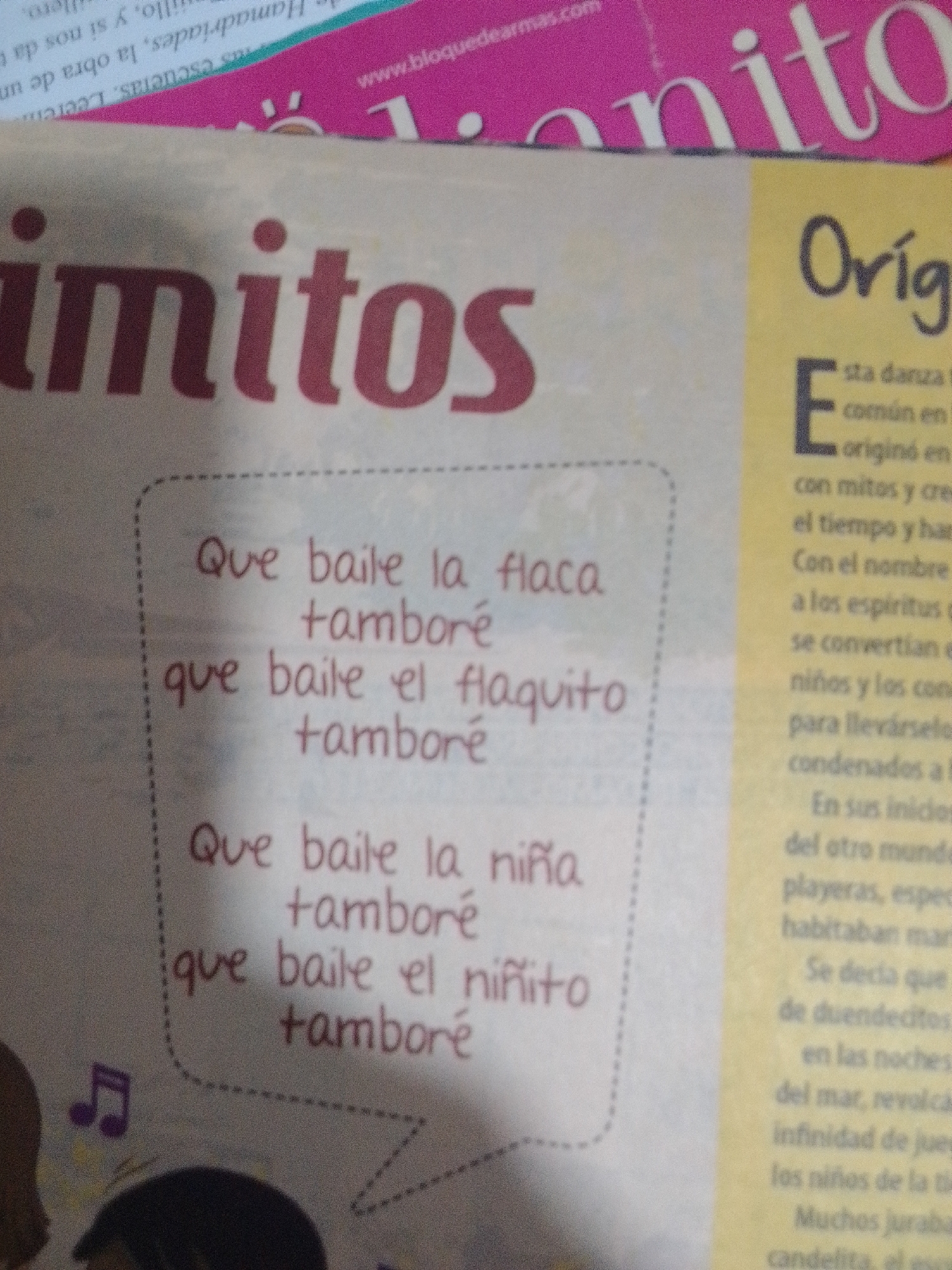 The image shows a close-up view of a magazine page. The dominant text in the foreground is in Spanish, with the word "mritos" prominently displayed. To the left, within a dotted outline, are three lines of text that appear to be song lyrics: "Que baile la tamboré", "que baile el flaquito tamboré", and "Que baile la niñita tamboré". There are also musical notes drawn to the left of the lyrics. To the right of the lyrics, there is text in a yellow-bordered section, also in Spanish, starting with the word "Oríg". Further text in this section is mostly illegible due to the image's resolution. The background shows a pink section with a website address, "www.bloquedearmas.com". There is no information or visual elements in this image that indicate any connection to La Tagua, Venezuela.
