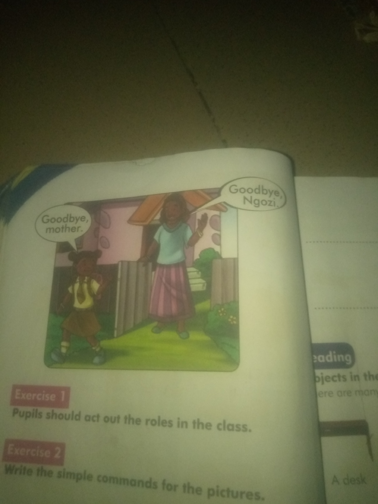 The image shows an open book with a cartoon illustration on the left page and text on both pages. The illustration depicts two figures in front of a house. A younger figure, dressed in a school uniform with a brown skirt and yellow shirt, is speaking to an older figure, who is wearing a blue top and a pink skirt. Speech bubbles indicate a conversation: the younger figure says, "Goodbye, mother," and the older figure says, "Goodbye, Ngozi." Below the illustration are two headings: "Exercise 1" and "Exercise 2." Under "Exercise 1," the text reads, "Pupils should act out the roles in the class." Under "Exercise 2," the text reads, "Write the simple commands for the pictures." The right page of the book contains some text that is partially visible and appears to be related to reading or vocabulary. The scene is set outdoors, with grass and a fence visible in the background of the illustration. The lighting suggests it is daytime. There is no information in the image to suggest a specific location in Jauro Yinu, Nigeria.