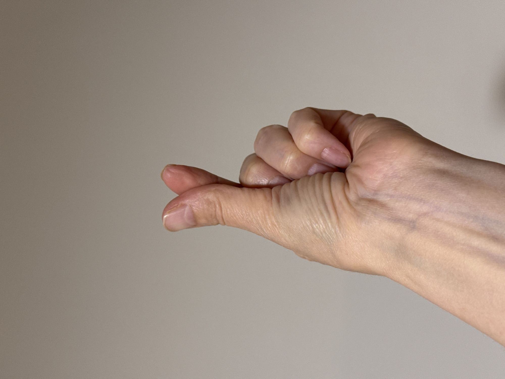 A close-up image shows a right hand with the pinky finger extended. The other fingers are curled inward. The skin tone is fair. The background is a solid, light gray color. There is no indication of a location in Izhevsk, Russia or any other specific location.