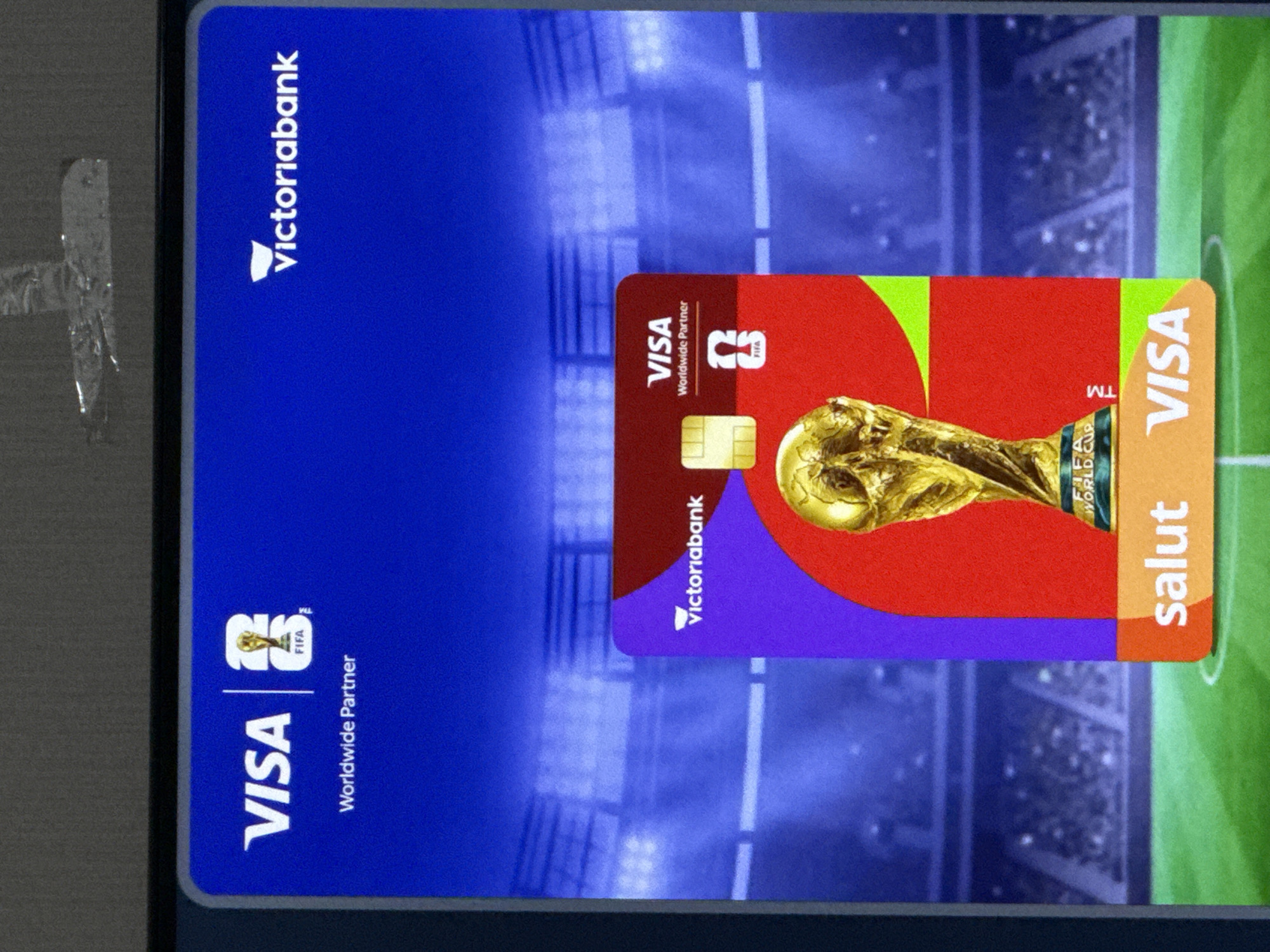 A screen displays a Visa card with the FIFA World Cup trophy and the Victoriabank logo. The screen shows a stadium backdrop, suggesting a promotional display for a banking partnership with the FIFA World Cup. The image does not provide any information about the city of Cahul, Moldova.