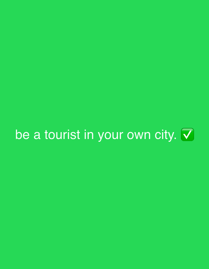 The image presents a minimalist graphic composed of white text and an emoji set against a solid, uniform green background. The background is a vibrant, consistent shade of green, devoid of any patterns, textures, or visual depth.
Centered horizontally and positioned in the lower-middle section of the frame, the text reads: "be a tourist in your own city." The characters are white, sans-serif, and appear digitally rendered with clean edges. To the immediate right of the text, a standard green checkmark emoji is displayed. This emoji features a white checkmark symbol enclosed within a square shape with slightly rounded corners, rendered in a green tone identical to the background, and outlined by a thin, darker green border.
The image contains no visual elements, landmarks, geographical features, or contextual clues that would allow for its specific localization within the city of Jos, Nigeria, or any other physical location. The scene depicts a purely digital graphic. There are no people, identifiable subjects, specific physical objects, or depicted actions or interactions within the frame. The environment is abstract, characterized solely by its color, text, and emoji content.