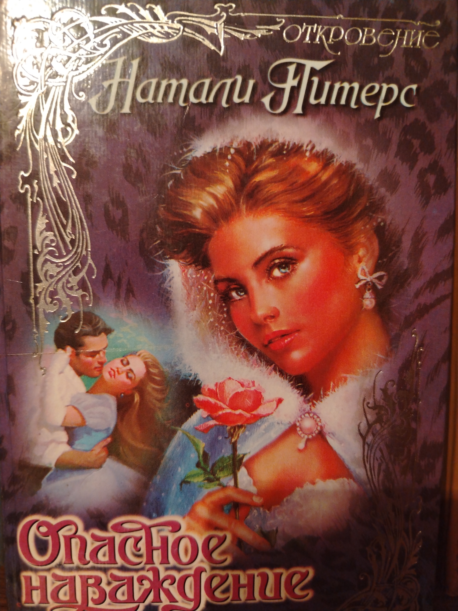 The image is a close-up of the cover of a book titled "Натали Гітерс. Откровенне Наваждение" (Natali Giters. Confident Delusion). The cover art depicts a romantic scene with a man and woman embracing, and a close-up of a woman's face with a rose. The background features a purple, leopard-print pattern. The book title is in large, stylized Cyrillic letters with silver decorative elements. The location in the city of Kolppana, Russia is not indicated in the image itself, as the image is of a book cover.