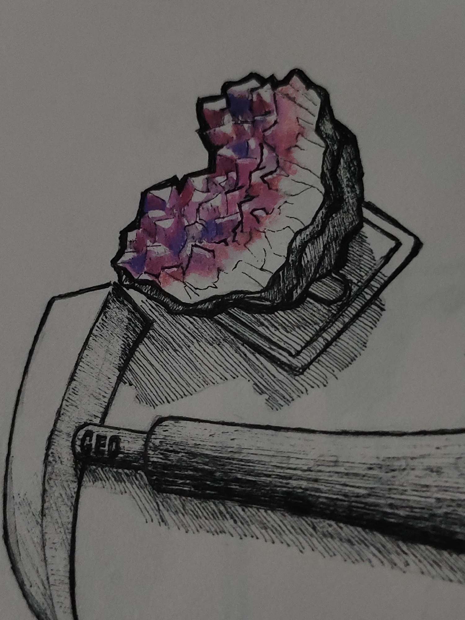 An illustrative depiction features a geological hammer positioned horizontally in the lower portion of the frame, with its pick-axe head facing left and its handle extending towards the right. The letters "GEO" are discernible on the hammer's metallic neck. Resting on a stack of flat, rectangular objects in the upper-right quadrant is an irregular cluster of crystals, predominantly displaying shades of purple and pink, suggesting a mineral specimen such as an amethyst geode. Both the hammer and the crystal cluster are outlined in black ink, with internal hatching and cross-hatching providing shading and texture. The crystal surfaces are rendered with polygonal facets. The background is a plain, light grey surface, indicative of paper or a neutral wall.