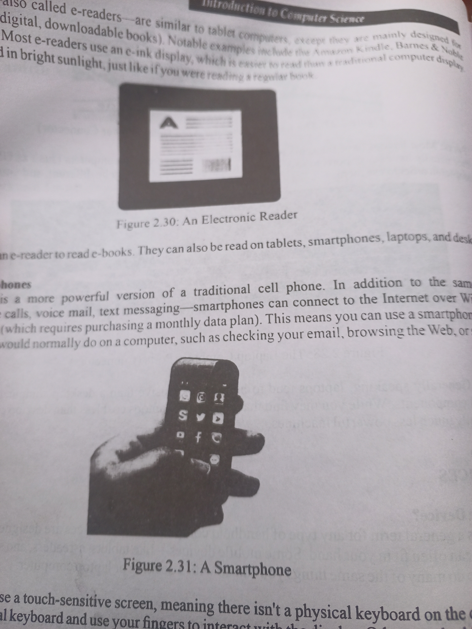 This media file is a photograph of an open textbook. The text discusses electronic readers and smartphones.
The left side of the image features text describing e-readers, stating they are similar to tablet computers and designed for digital books. It mentions notable examples like the Amazon Kindle and Barnes & Noble e-readers, highlighting their e-ink displays that are easy to read in bright sunlight. An illustration labeled "Figure 2.30: An Electronic Reader" is also present, showing a device with a screen displaying text and a barcode.
The right side of the image continues with text discussing smartphones, describing them as powerful versions of traditional cell phones. It notes their ability to connect to the internet for tasks like checking email and browsing the web. A photograph labeled "Figure 2.31: A Smartphone" dominates this section, depicting a hand holding a smartphone. The phone's screen displays icons for various applications, including social media platforms. The text below this image explains that smartphones have touch-sensitive screens instead of physical keyboards.
The setting appears to be an indoor environment, likely a classroom or study area, given the context of a textbook. There are no specific time of day or weather cues visible. The overall tone of the text is informative and educational. There is no indication of people other than the hand in the smartphone photograph. There are no distinct location cues related to Jalingo, Nigeria.