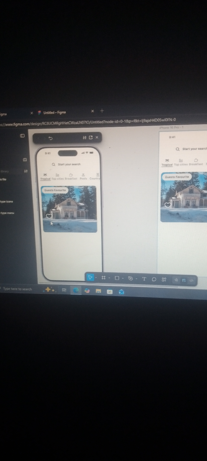 A computer screen displays a Figma design project. Two iPhone mockups show a travel app interface. The app's search bar prompts users to "Start your search." Below, a tab bar displays "Tropical," "Top cities," "Breakfast," "Pools," and "Country." A "Guests Favourite" section showcases an image of a house in a snowy landscape. A heart icon suggests a "like" feature. The Figma tab is open in a browser with the URL visible. A Windows taskbar with icons like "Type here to search" is visible at the bottom.