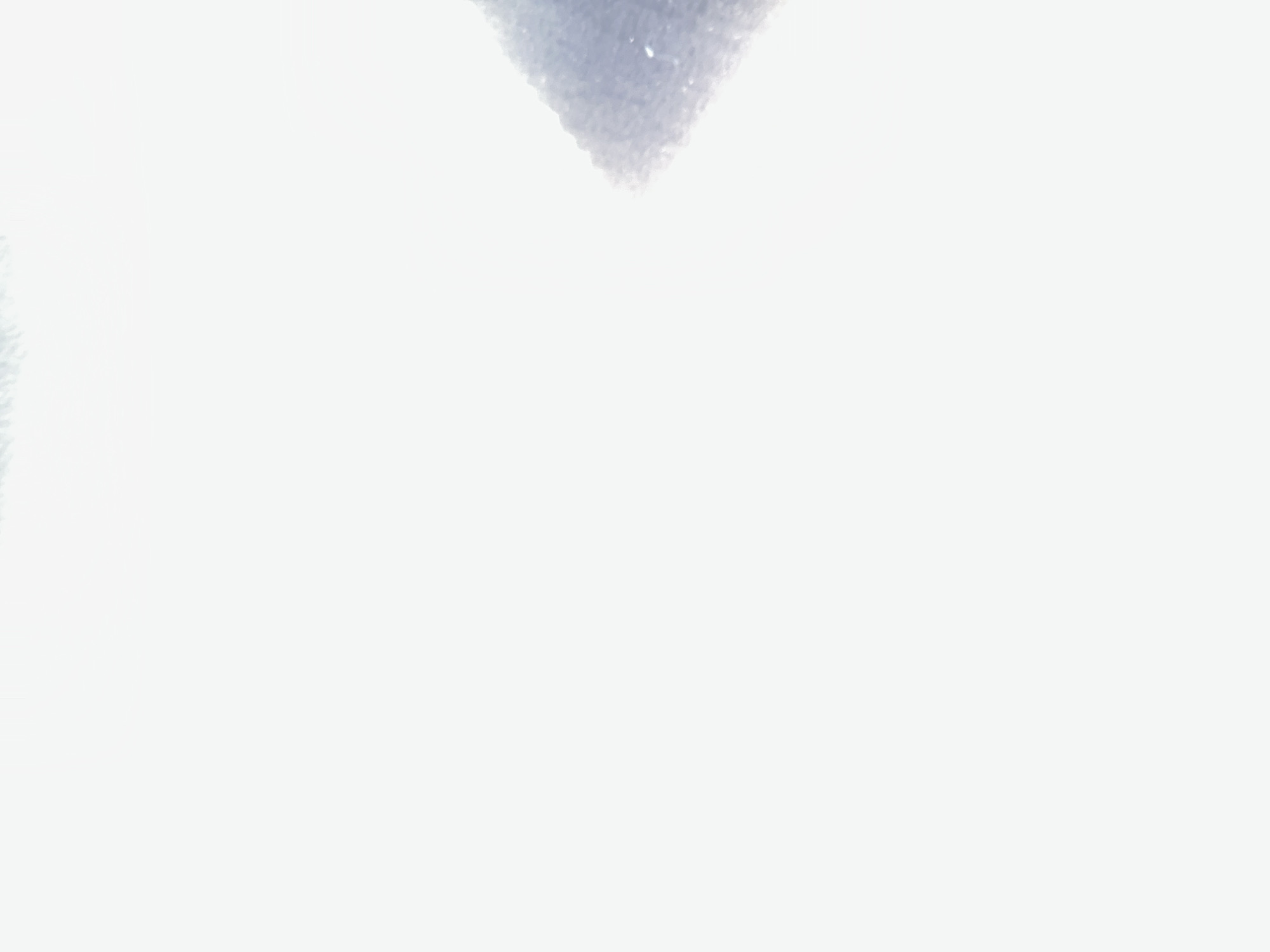 The image is a close-up shot of a watercolor painting with a soft, diffused light. The painting depicts a textured surface, possibly snow or fabric, in shades of gray and white. The texture is granular, with small dots and speckles visible, creating a sense of depth and detail. The composition is abstract, with a focus on texture and light. There are no discernible objects or people in the image, and it is not possible to determine its location within the city of Belgrade, Serbia.