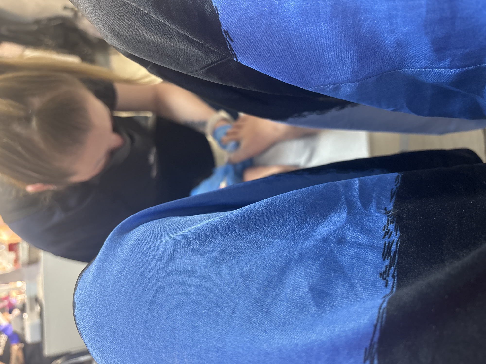 A person is receiving a pedicure in a salon. A blonde person wearing a black shirt is working on the customer's foot. The customer is wearing a white sandal and is reclined in a chair covered with blue and black fabric. The scene appears to be indoors, possibly in a salon setting. There is no information available to determine the location in Sofia, Bulgaria.