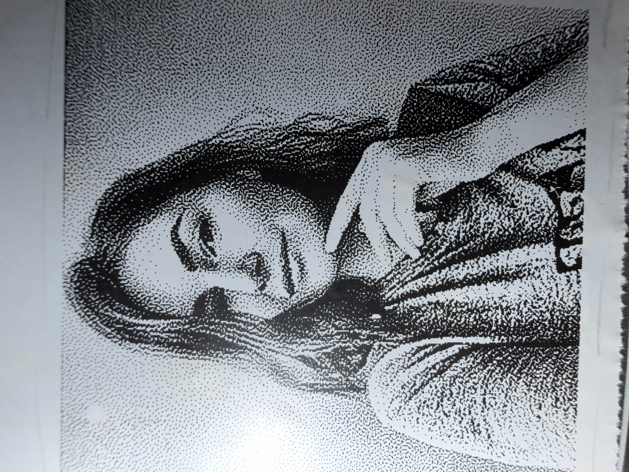 The image is a black and white stippled illustration of a woman lying down. Her head is tilted slightly to the left, and her eyes are closed. Her left hand is near her face. She is wearing a shirt. The background is a uniform stippled pattern. The location and city are not discernible from the image.